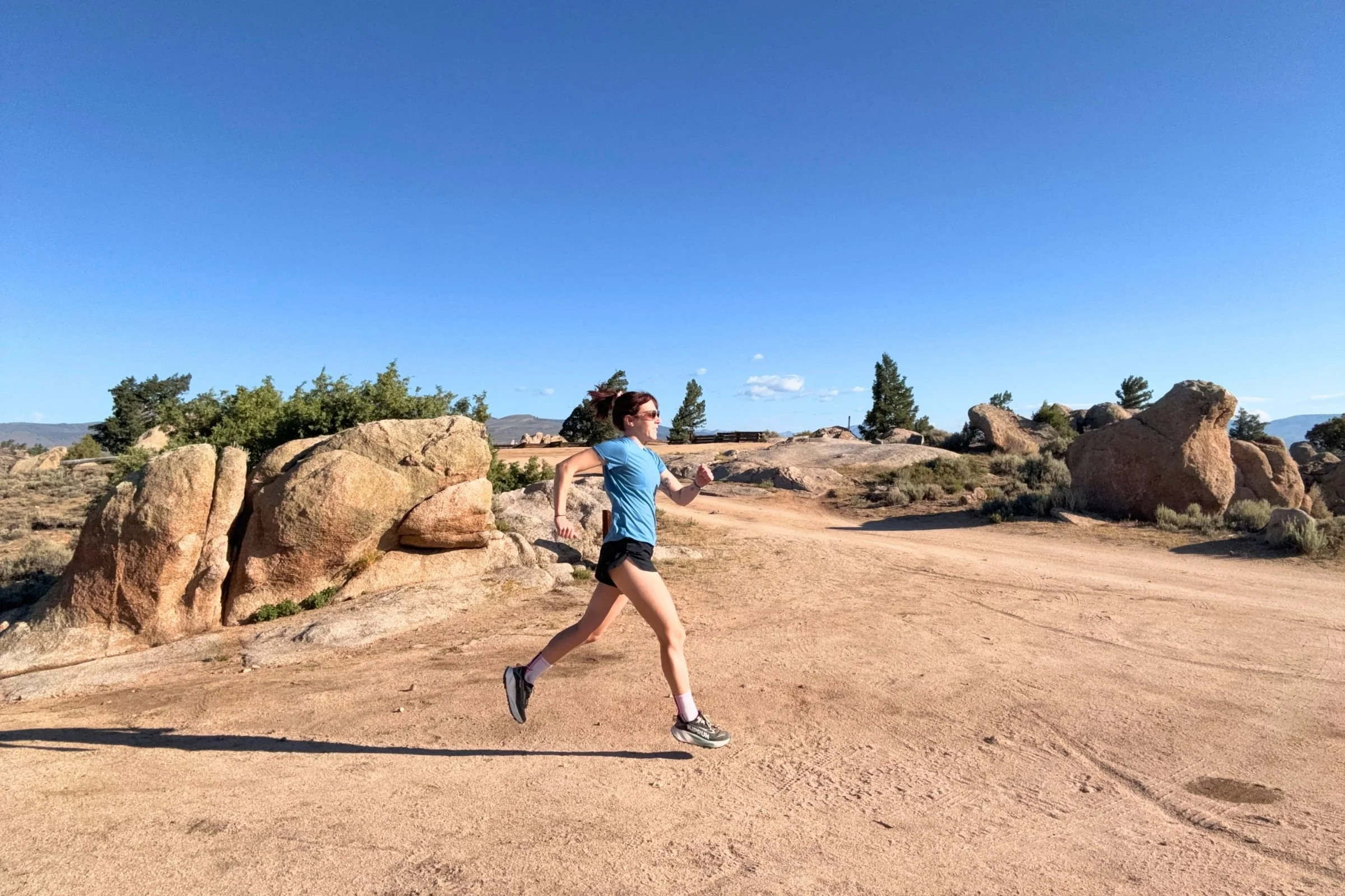   A runner wearing the Patagonia Capilene Cool Trail shirt while running through a rocky landscape.  