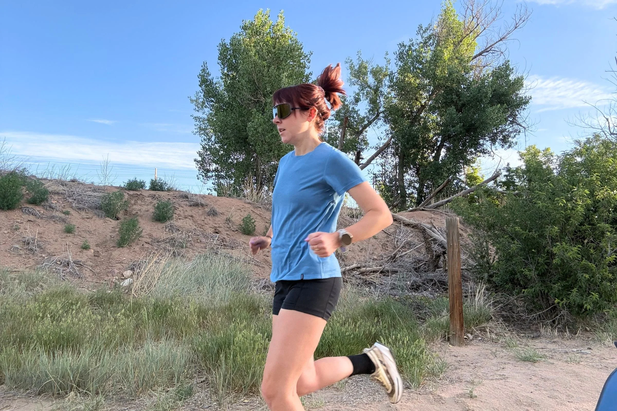   A runner wearing the Patagonia Capilene Cool Trail shirt on a grassy trail.  