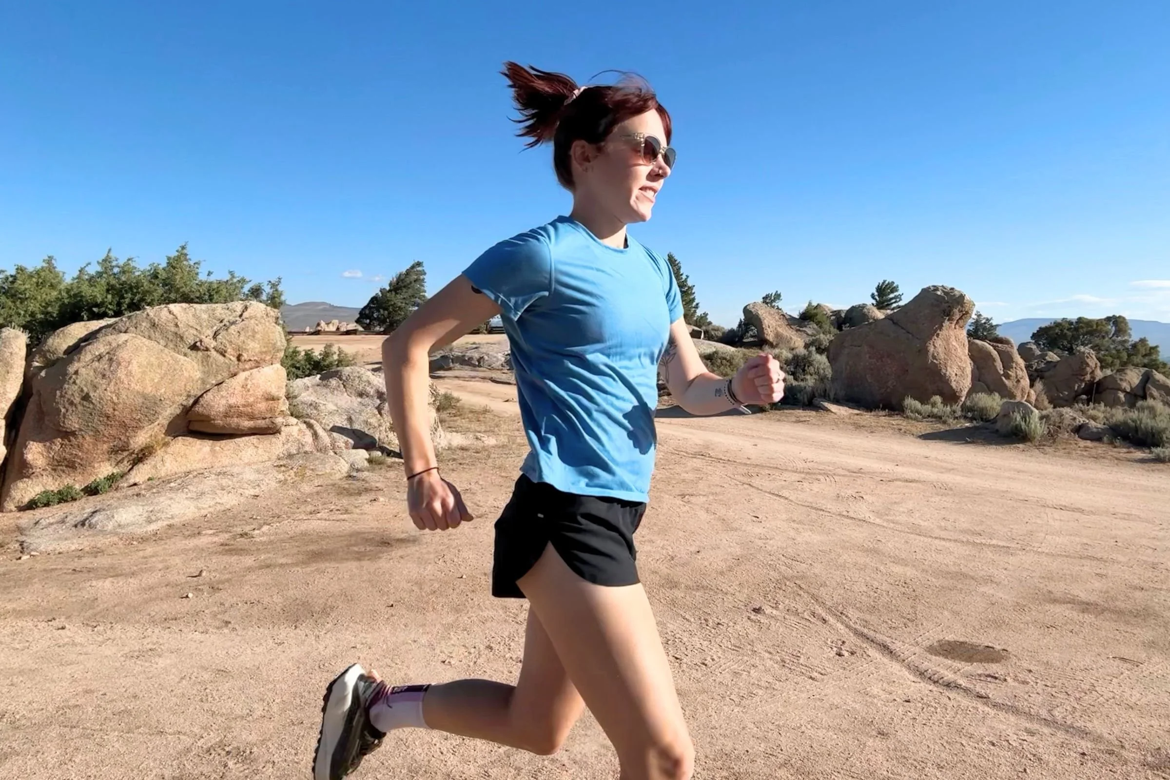   A runner wearing the Patagonia Capilene Cool Trail shirt while running through rocky terrain.  