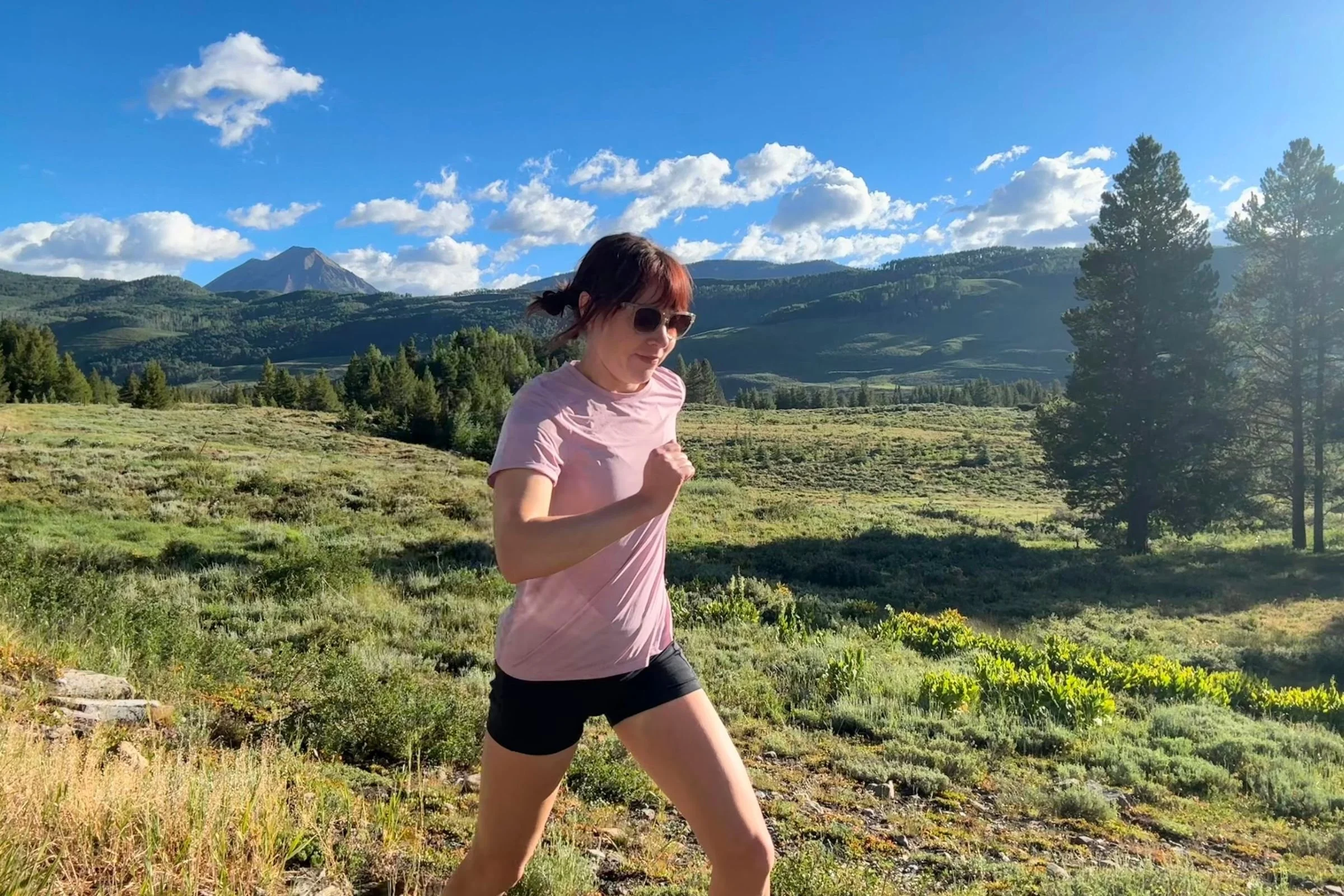  A runner wearing the Patagonia Capilene Cool Ultra shirt while running through a mountain landscape.  