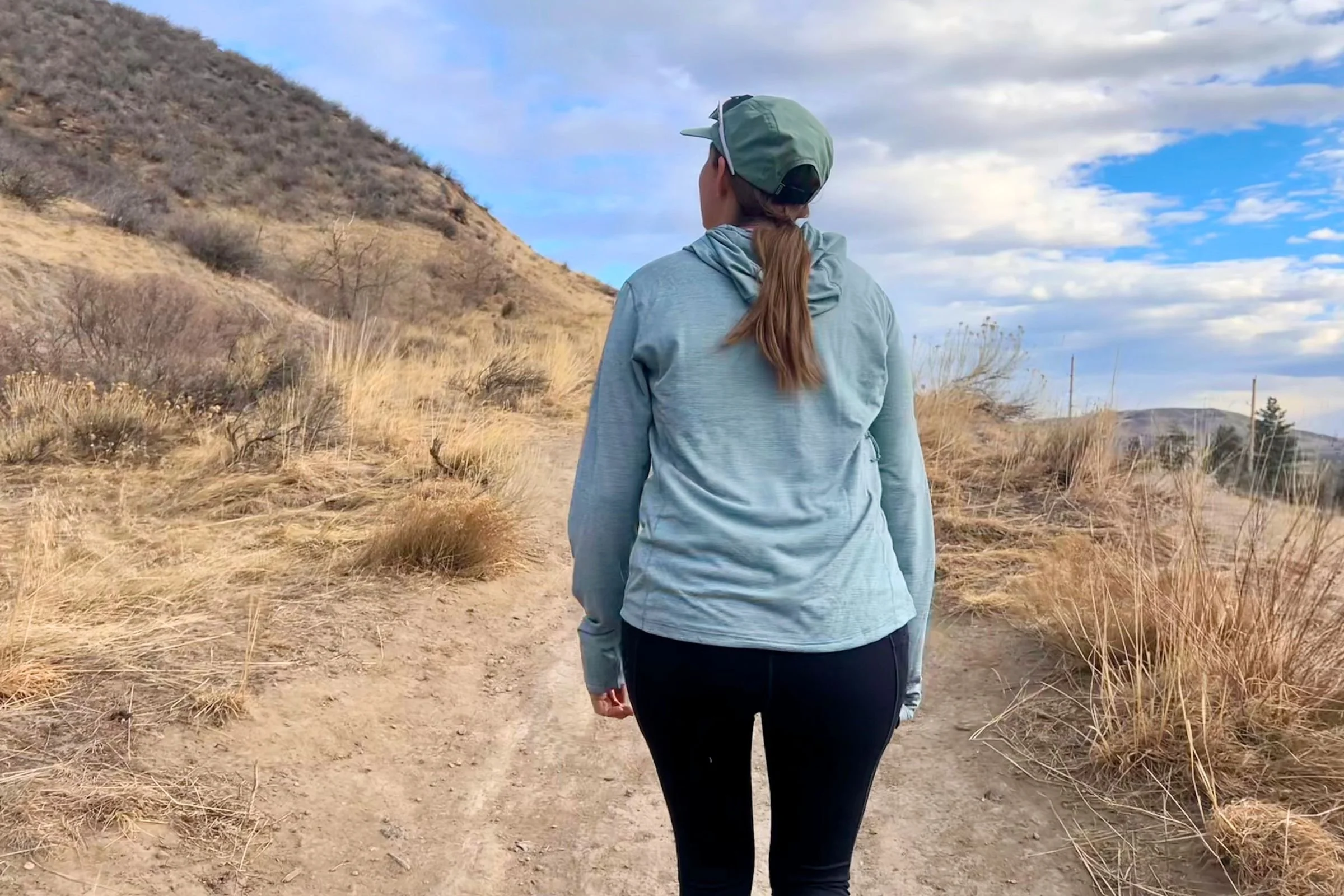   A runner wearing the Patagonia Capilene Cool Sun Hoody on a trail.  