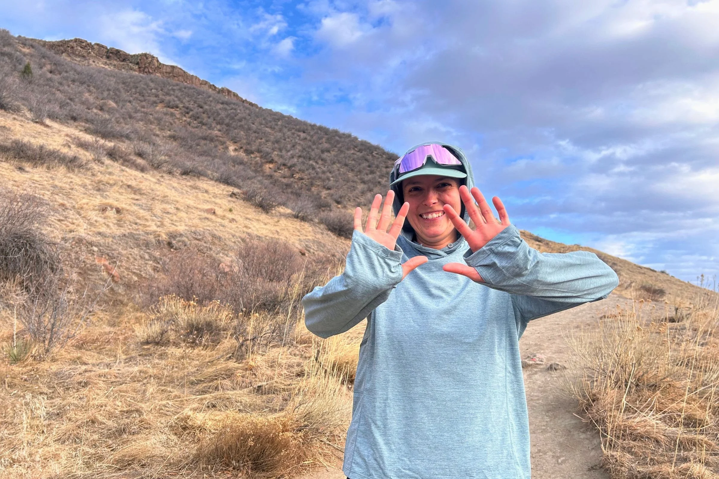   A runner wearing the Patagonia Capilene Cool Sun Hoody and showing the lightweight hood and fit.  