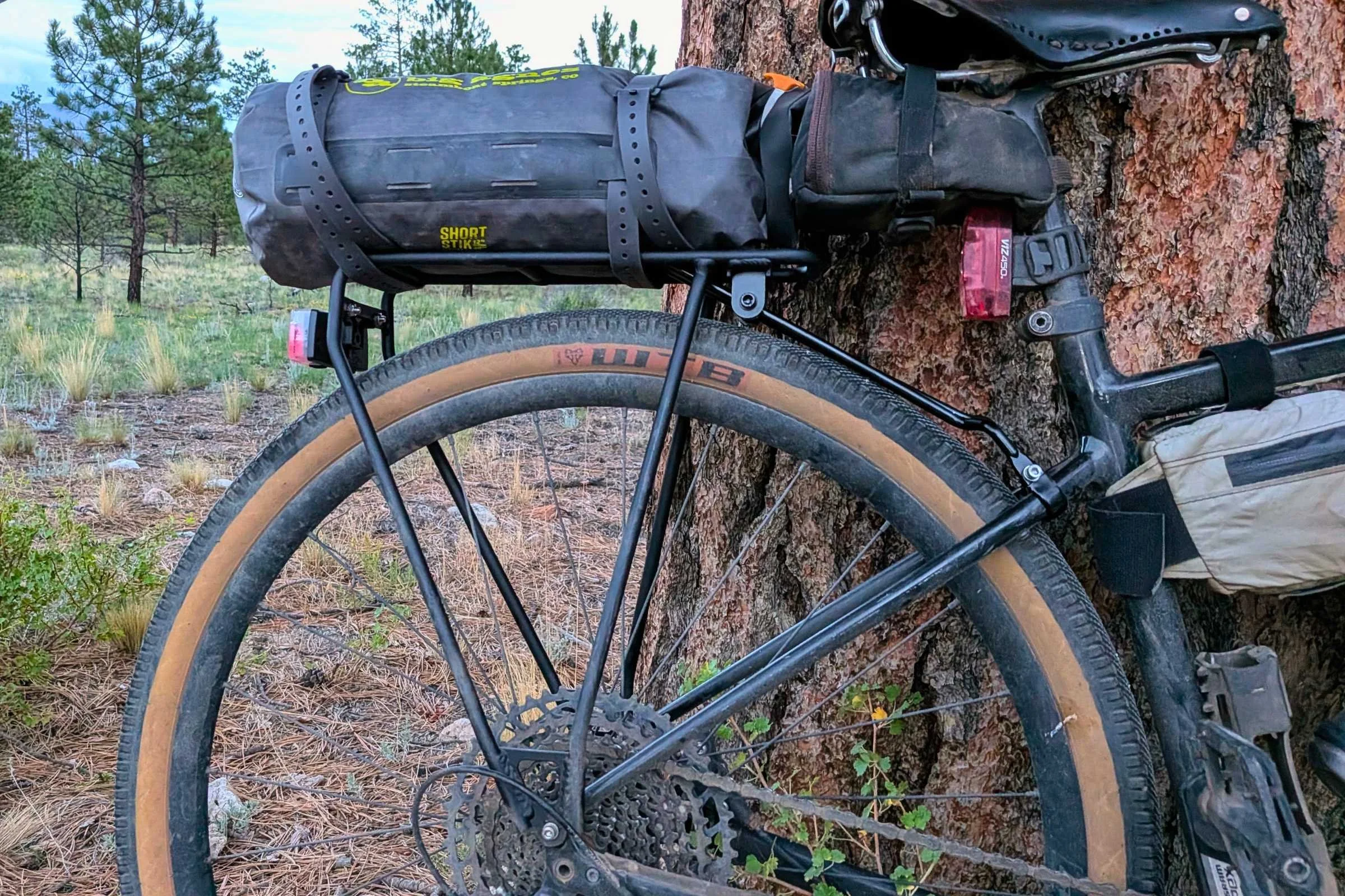   The Portland Design Works OxRack Rear Rack carries a tent and other bikepacking gear, showing its sturdy platform and adjustable supports.  
