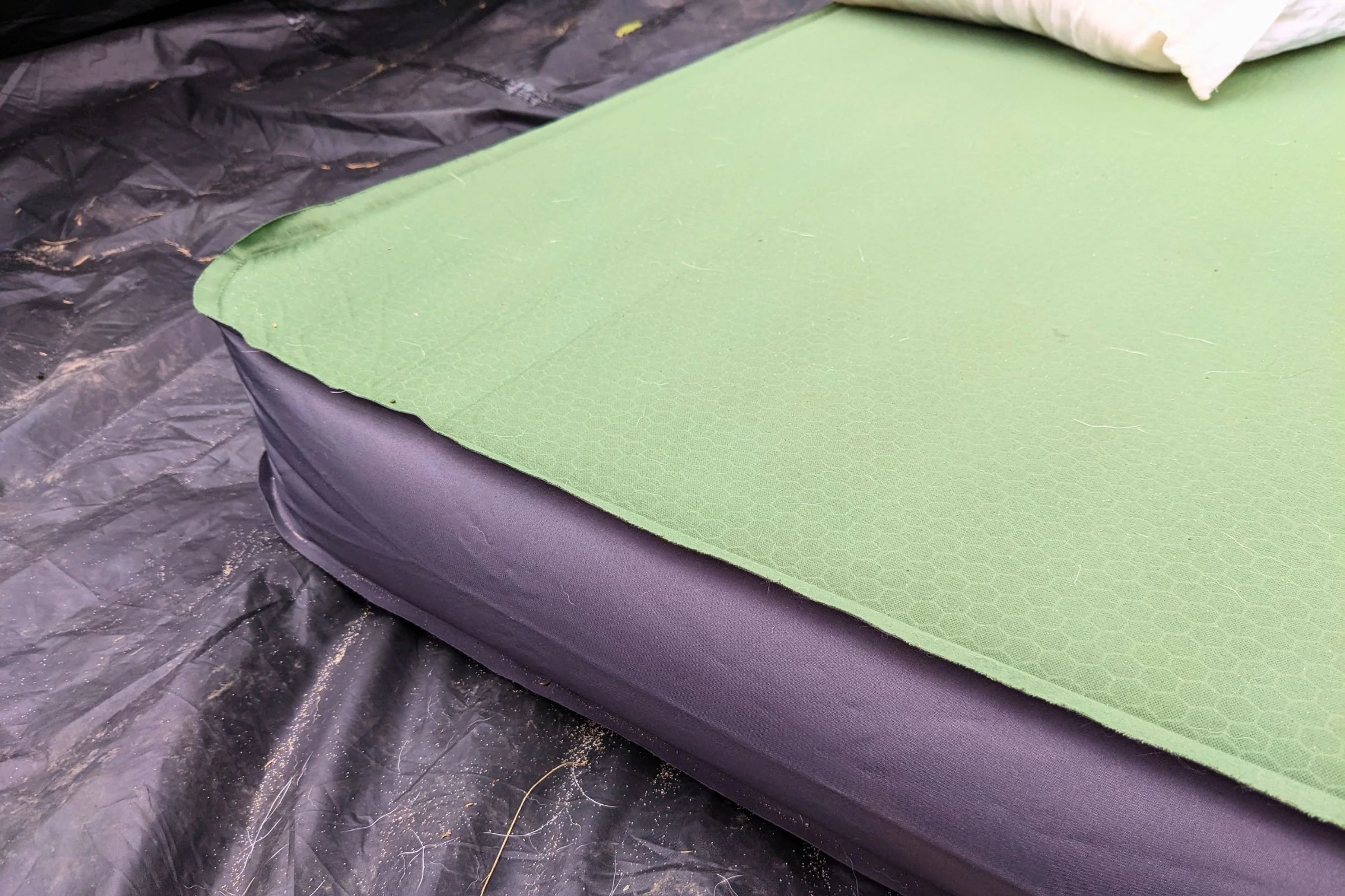   The EXPED MegaMat is fully inflated inside a tent, showing its generous cushioning and supportive sleeping surface.  