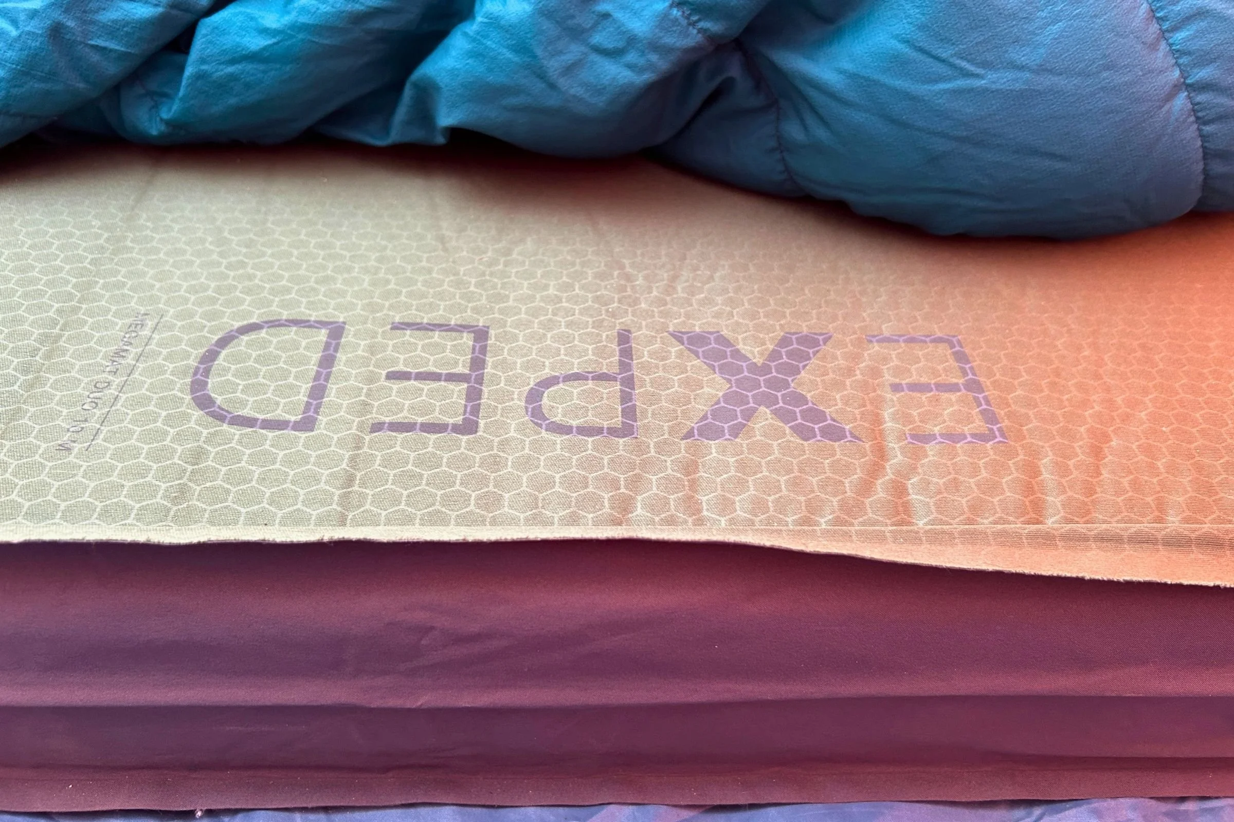   A close-up of the EXPED MegaMat Duo shows its cushioned sleeping surface and layered construction.  