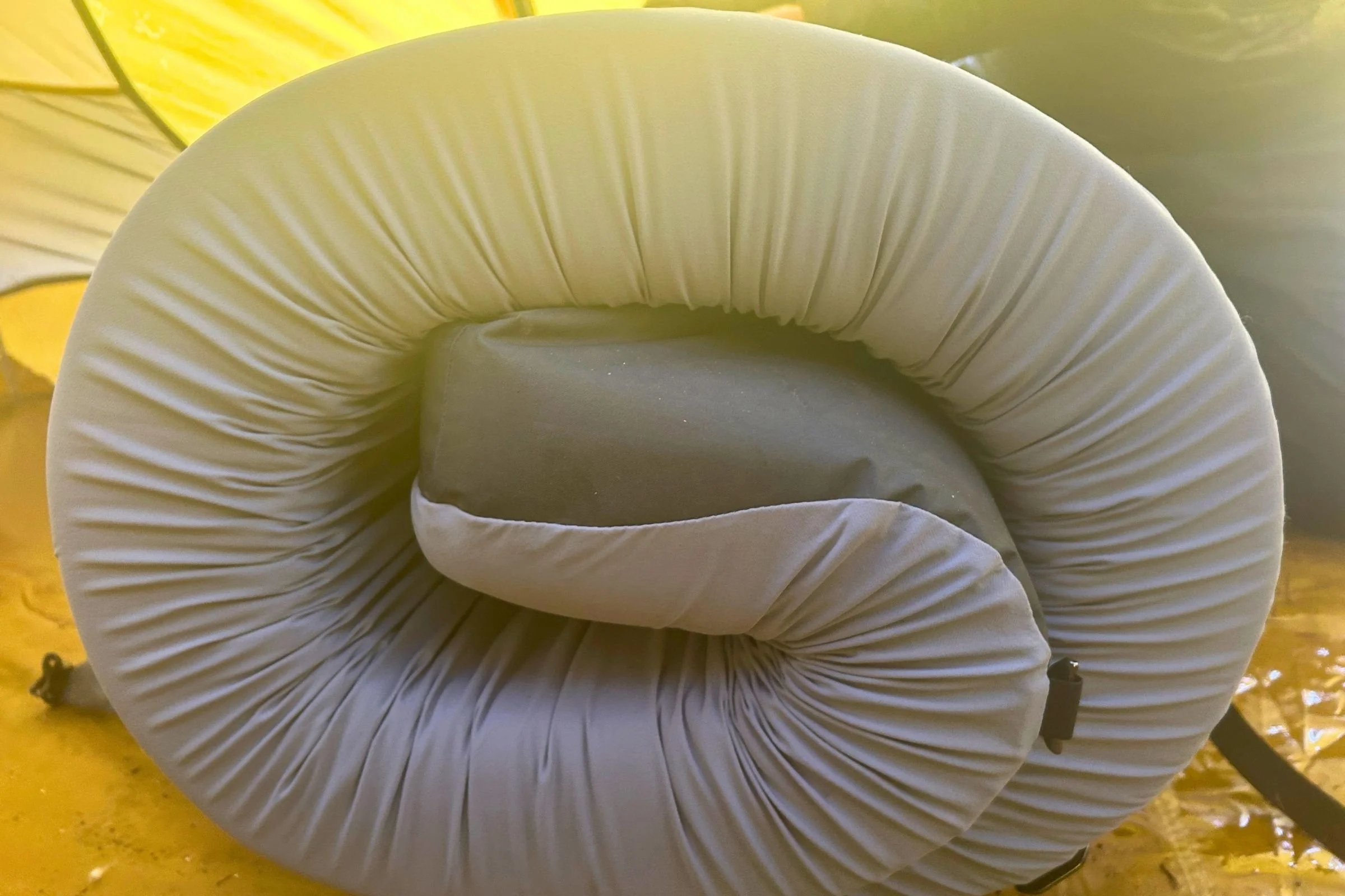   A close-up of the rolled HEST Sleep System Sleeping Pad shows its thick foam layers and compact rolled shape.  