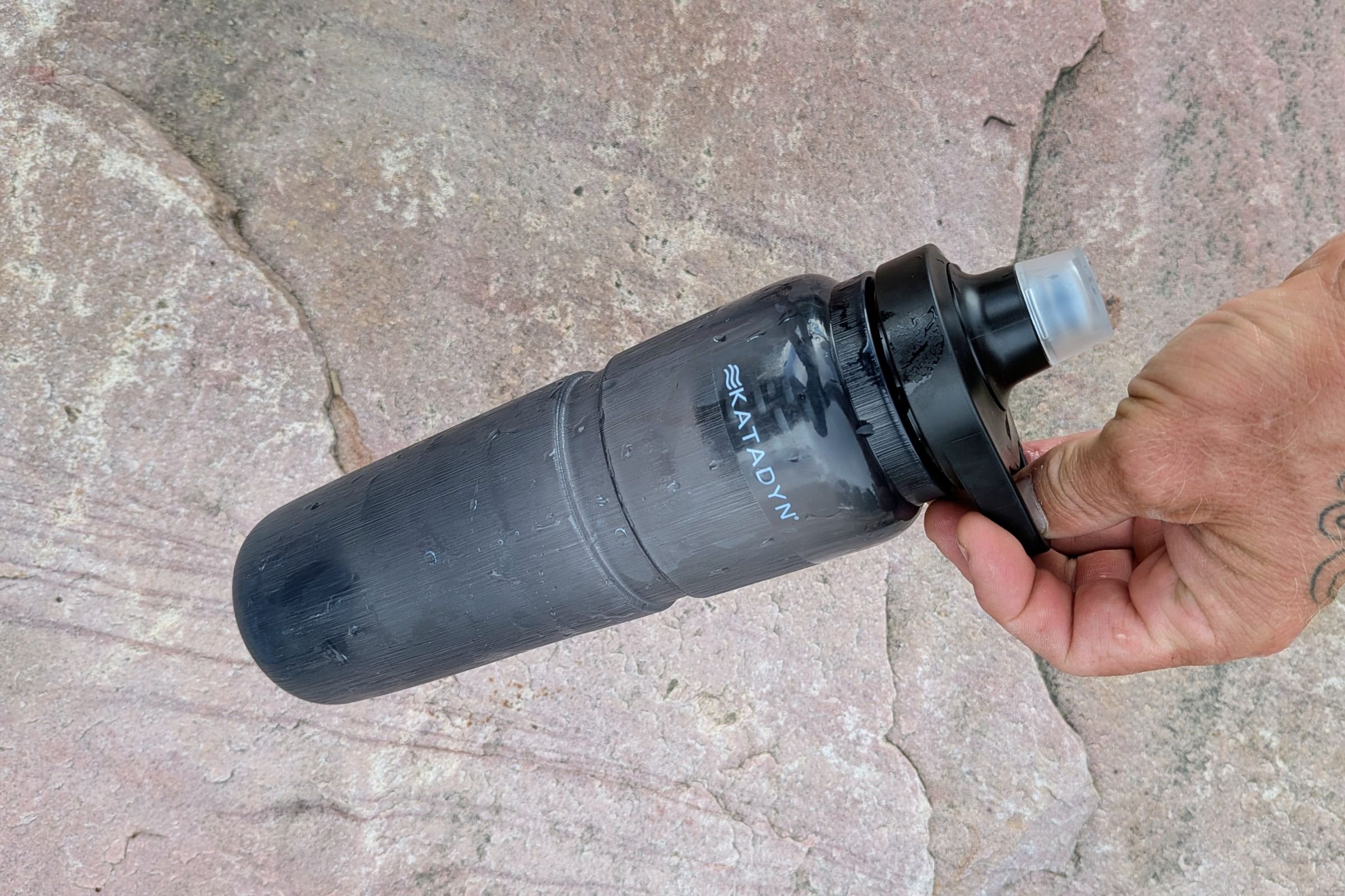   The Katadyn BeFree AC Bottle’s squeezable body and sport cap are shown in use, highlighting the bottle’s flexible construction despite its hard-sided design.    