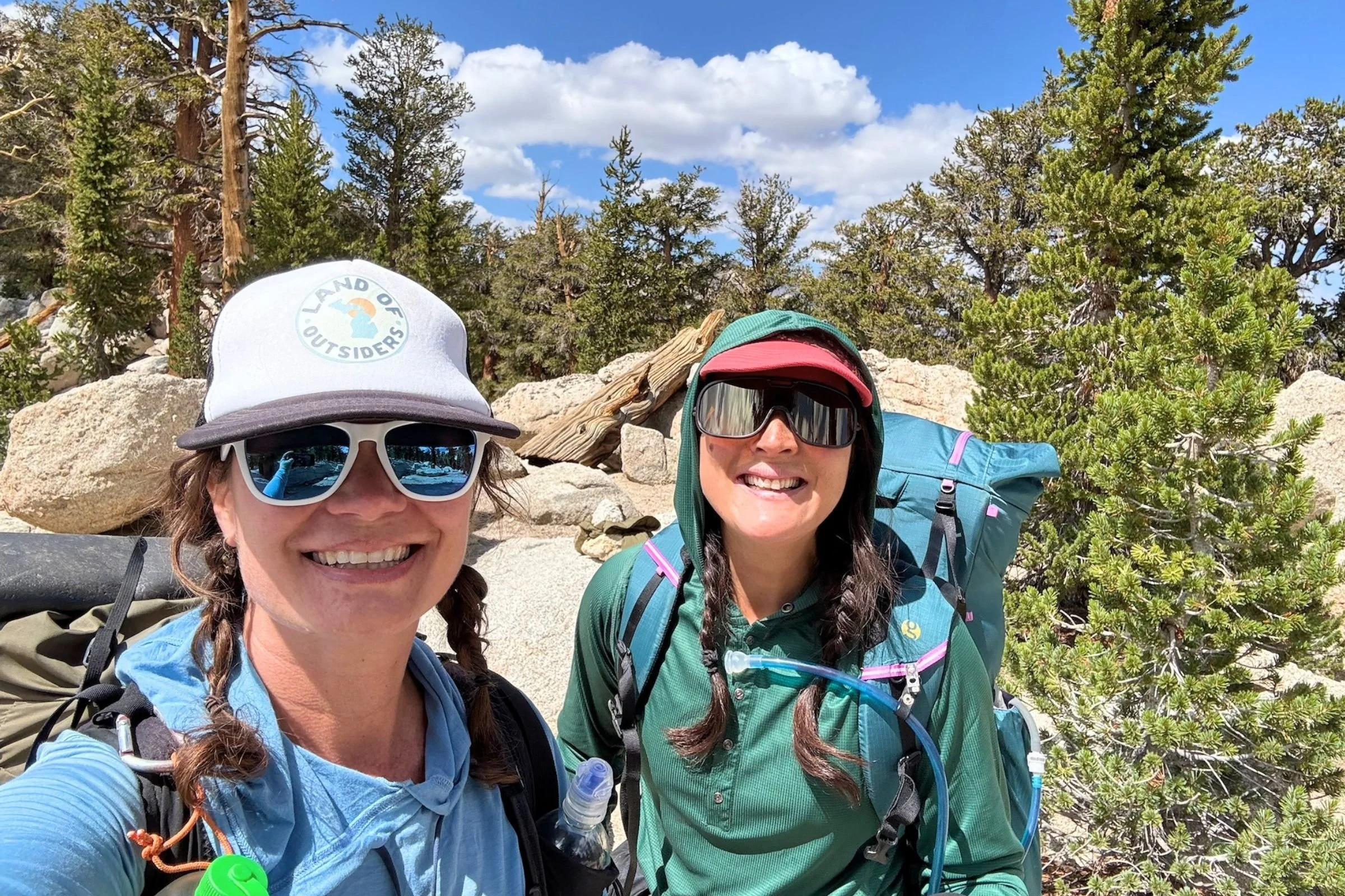   Hikers wear the Gossamer Gear Mariposa 60 on the trail, showing the pack’s comfortable fit and streamlined profile in use.  