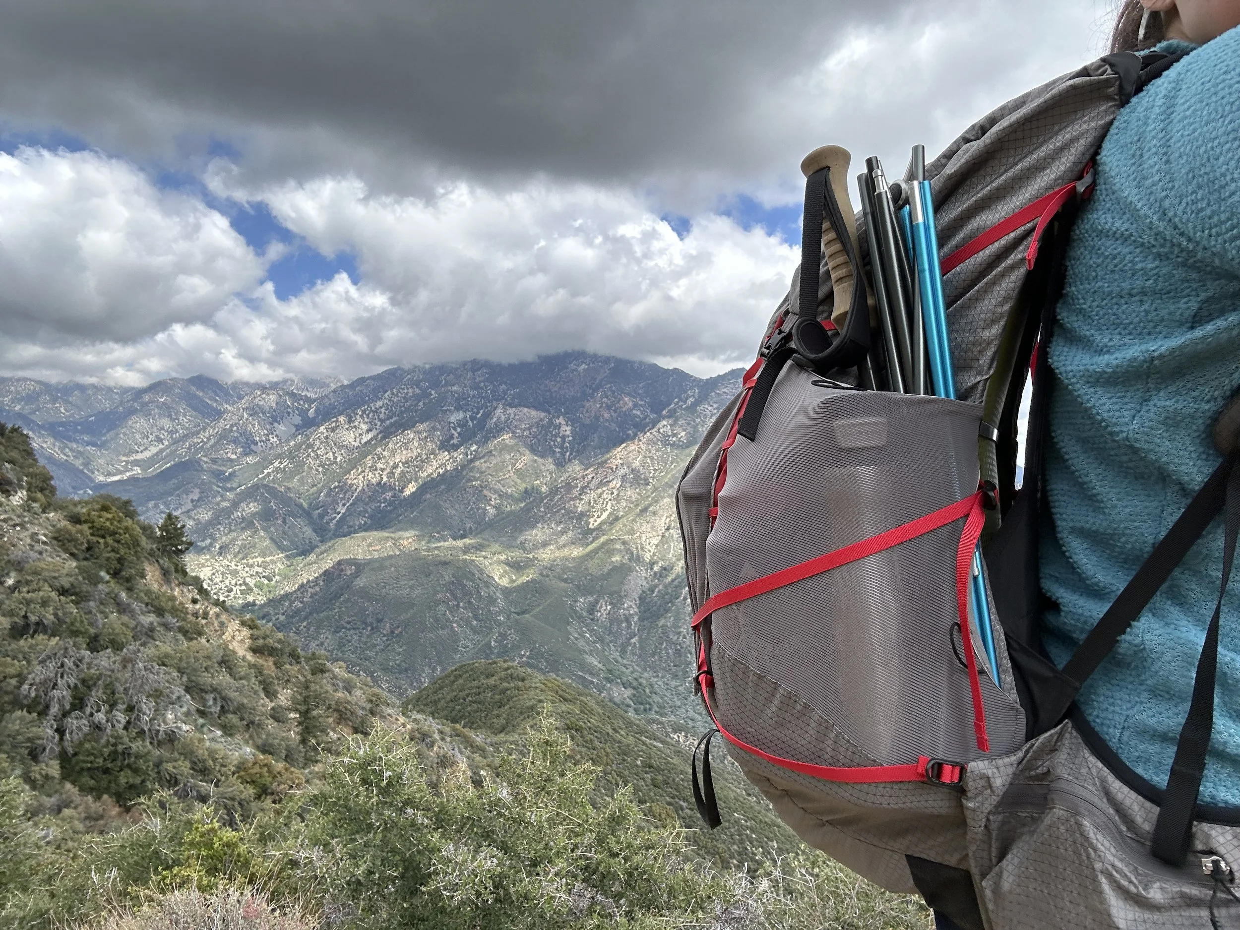  The deep mesh side pockets on the Exos/Eja Pro 55 can hold a full insulated water bottle and tent poles. You can see the dual access point on the right where the blue tent poles are more visible. Here, we’re on a trip in the San Gabriel Mountains N
