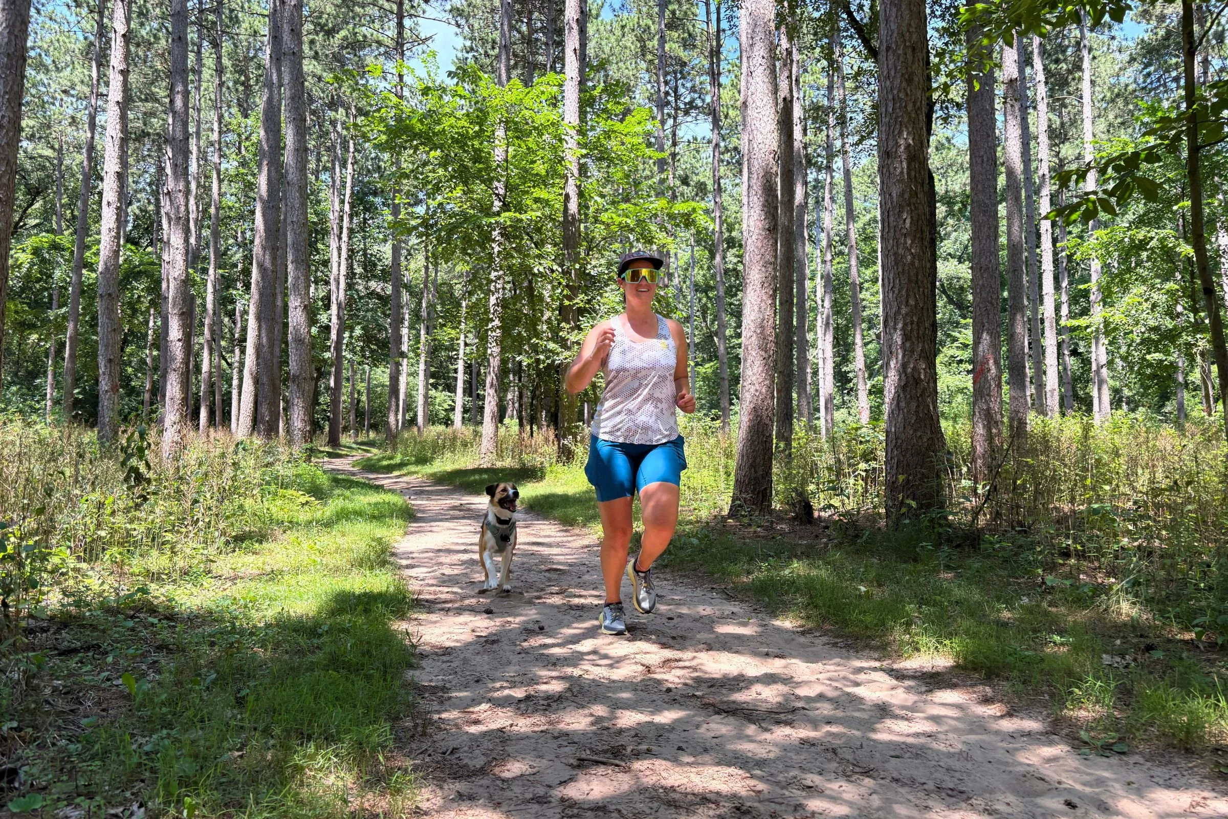   The Janji Pace Shorts’ high waistband and close-fitting design stay comfortably in place as a runner makes her way along a forest trail.  