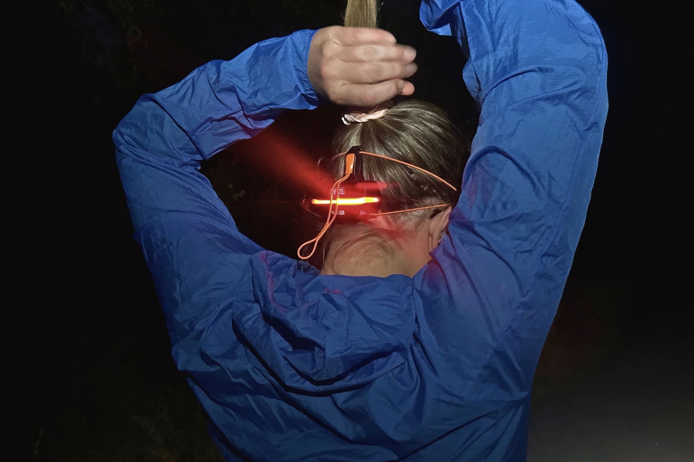   We tested the Petzl NAO RL with long hair and found the tall rear battery pack and elastic headband can interfere with ponytails and braids.  