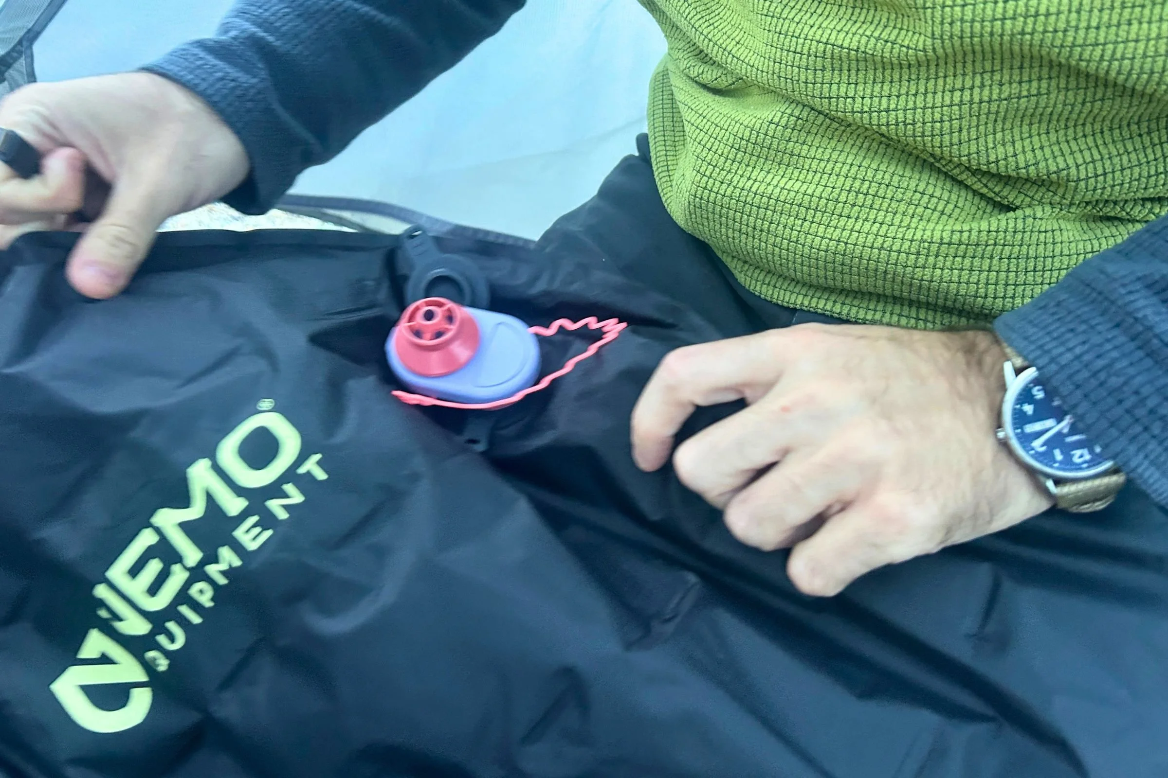   A tester uses the Alpenblow Lux to inflate a NEMO sleeping pad; the pump works with adapters for NEMO and several other major sleeping pad brands.  