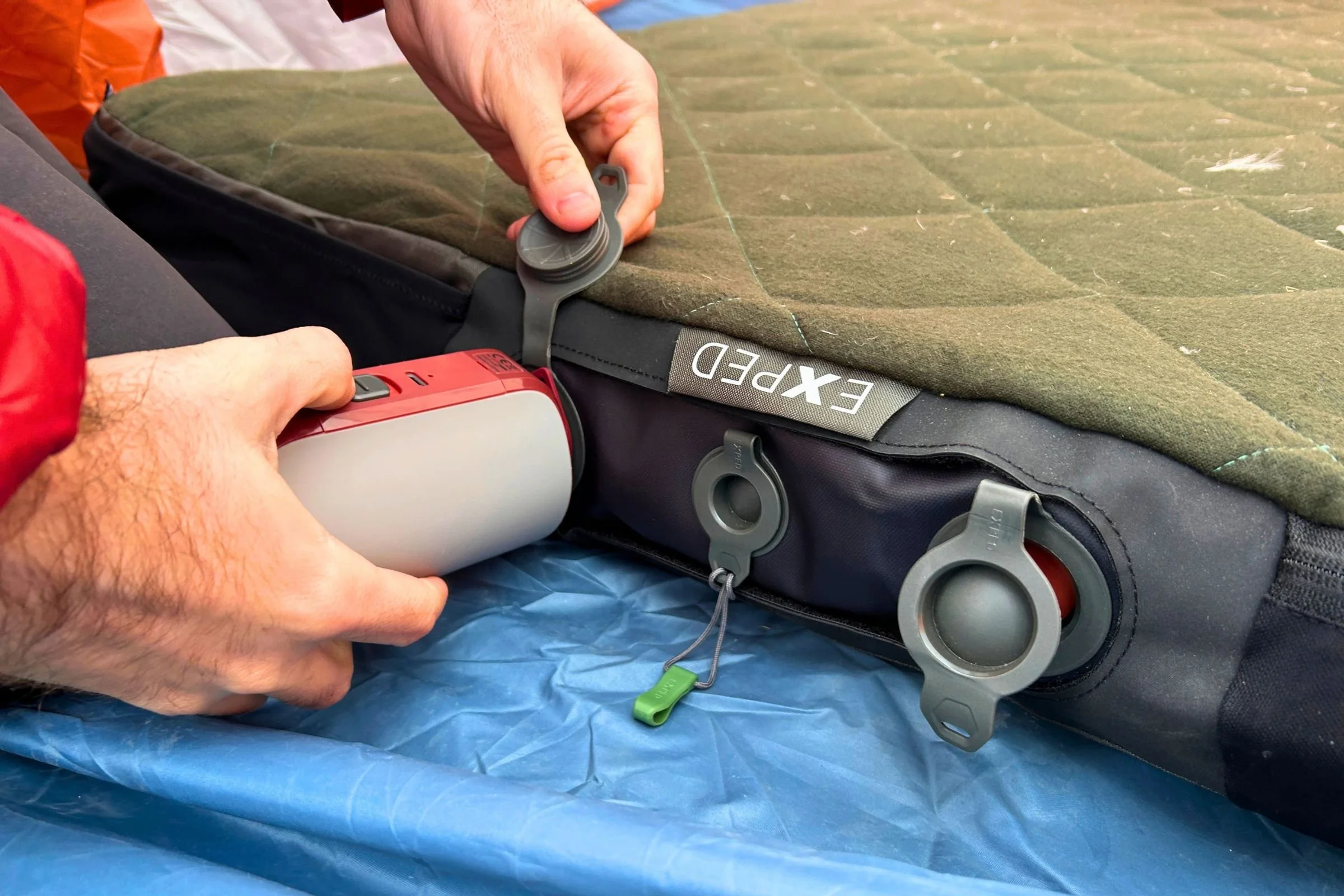   A tester connects the EXPED Mega Pump to an EXPED MegaMat; the rechargeable pump handles both inflation and deflation, making it much easier to pack the bulky mattress back into its stuff sack.  