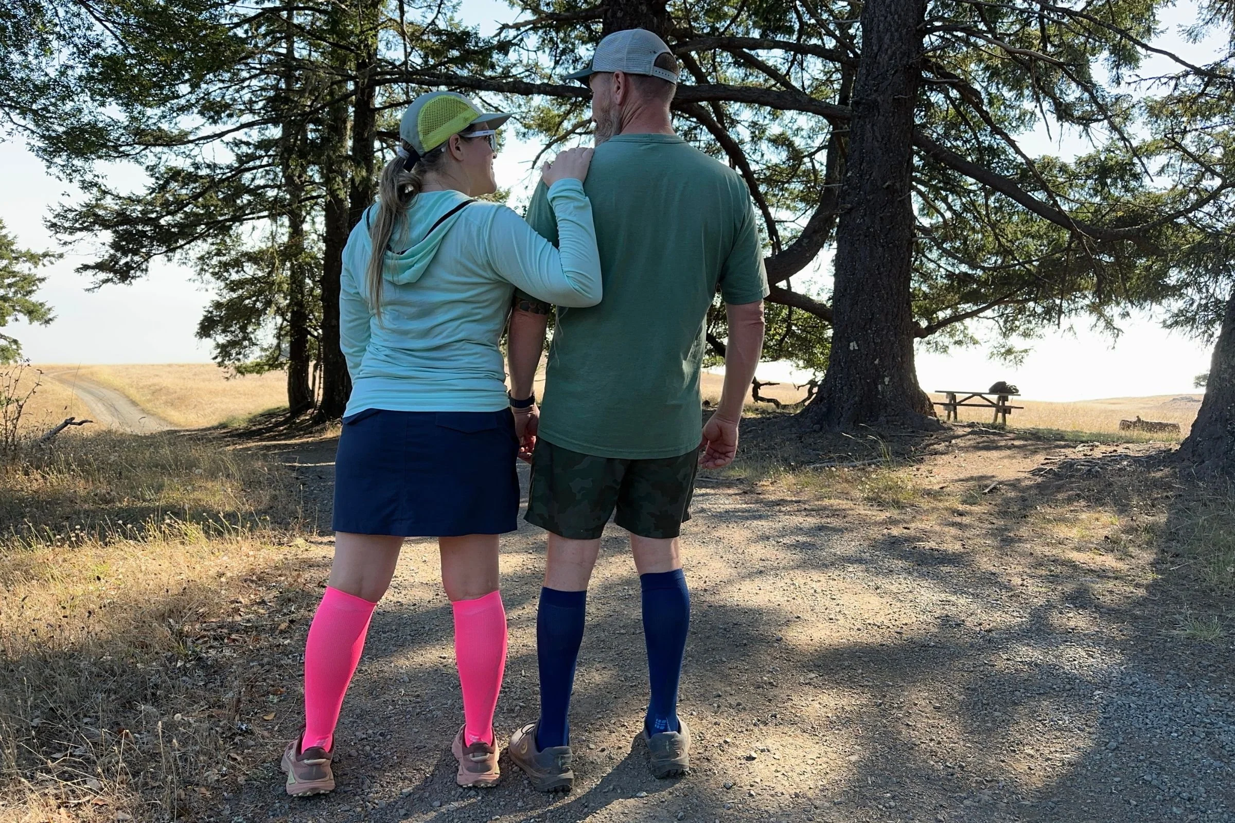   Two runners wear the CEP Core Run Tall Compression Socks 5.0 during a sunny trail outing. The knee-high socks stay comfortably in place without digging into the calves, even during long runs in hot weather.  
