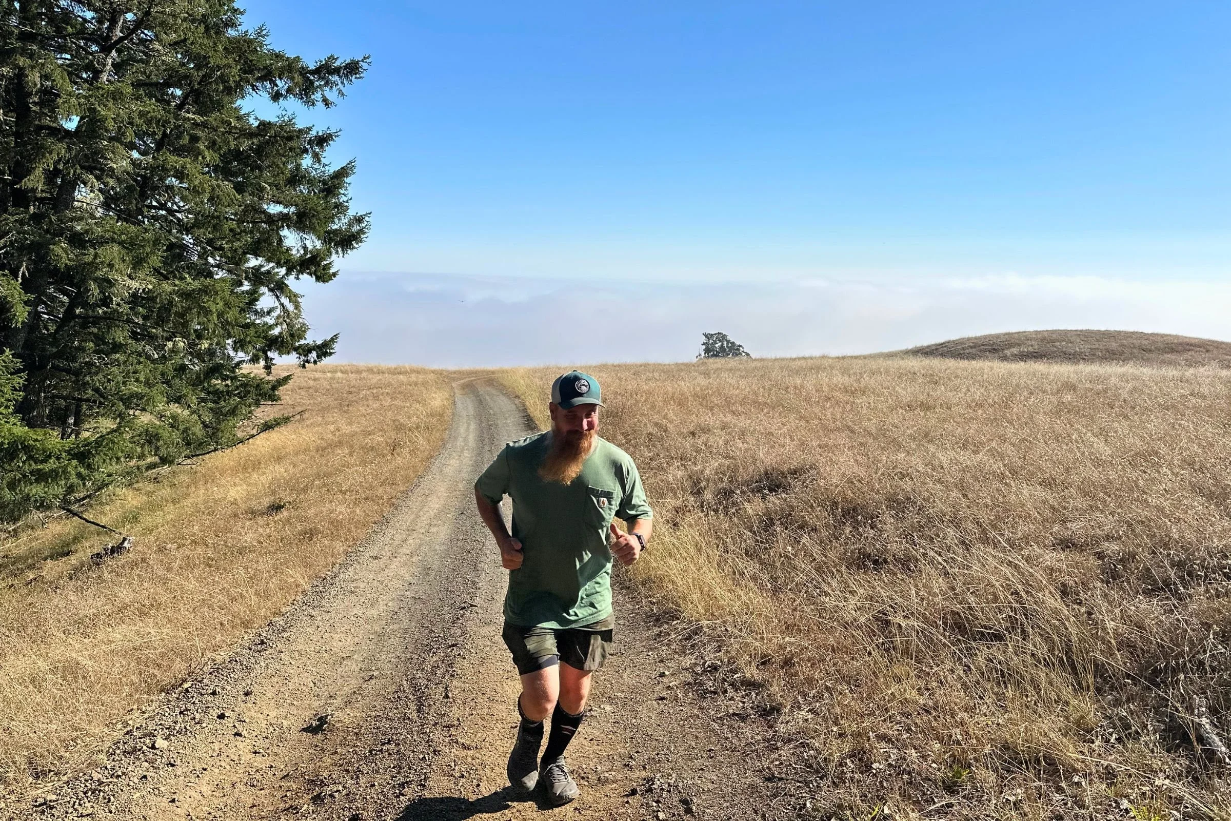   A runner tests the Rymora Compression Socks on an exposed, sunny trail, where their supportive fit holds up over long distances, though the thicker fabric can feel warm in hot weather.  