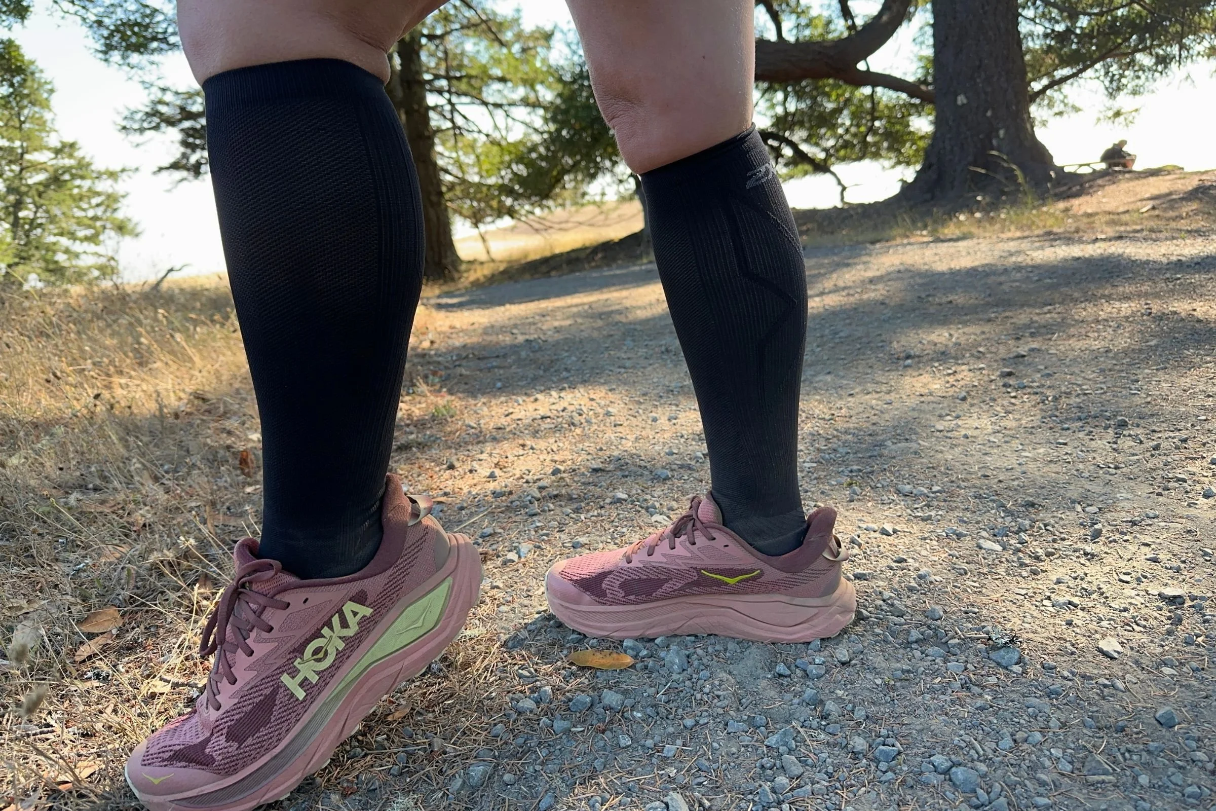   A side view of the 2XU Vectr Cushion Full Length Compression Socks shows their knee-high fit and targeted shin support, with graduated compression designed for runners dealing with shin splints.  