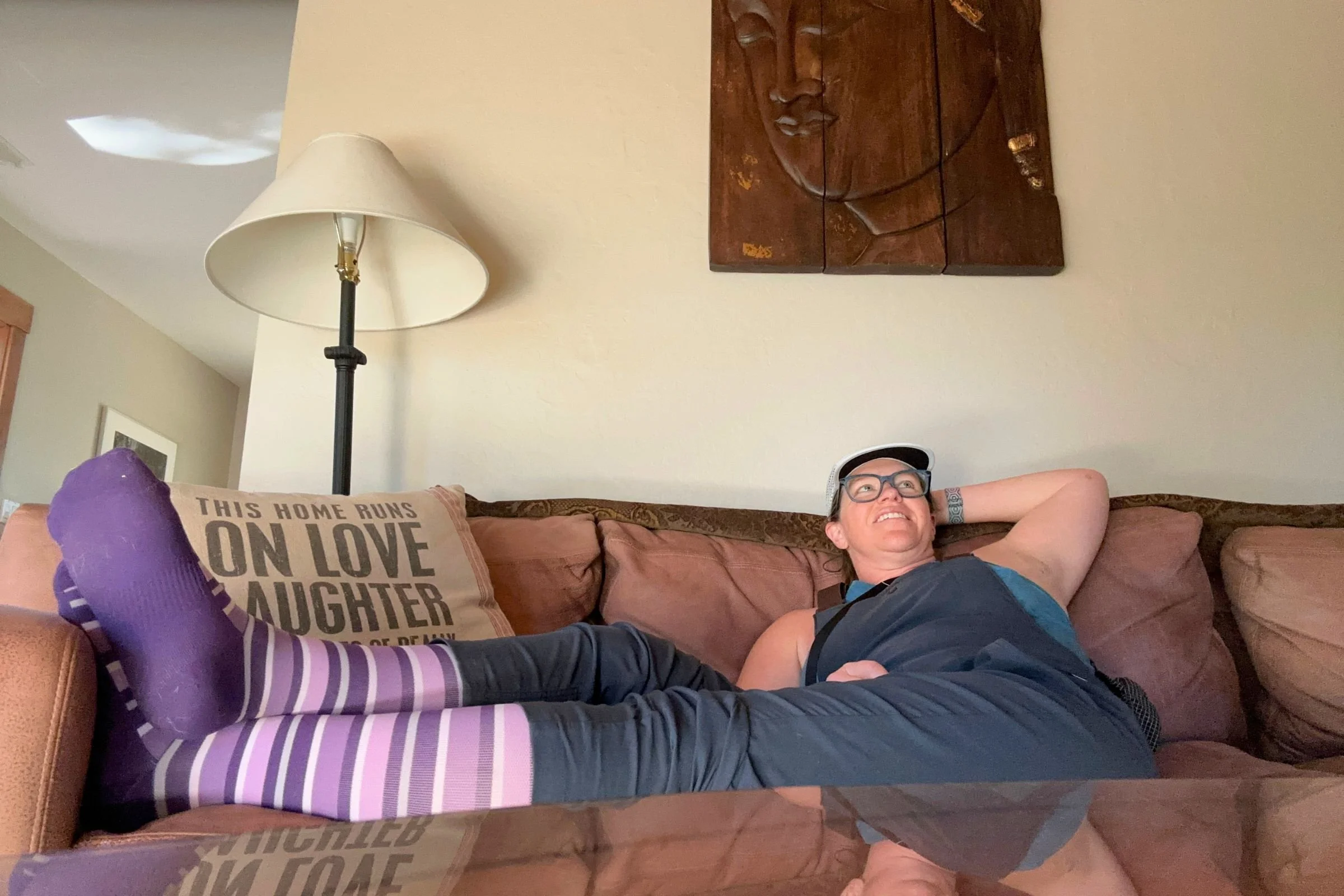   A tester relaxes on the couch with her feet up in the OS1st Wellness Compression Socks. Their gentle 15–20 mmHg compression makes them our favorite pair for rest days and post-workout recovery.  