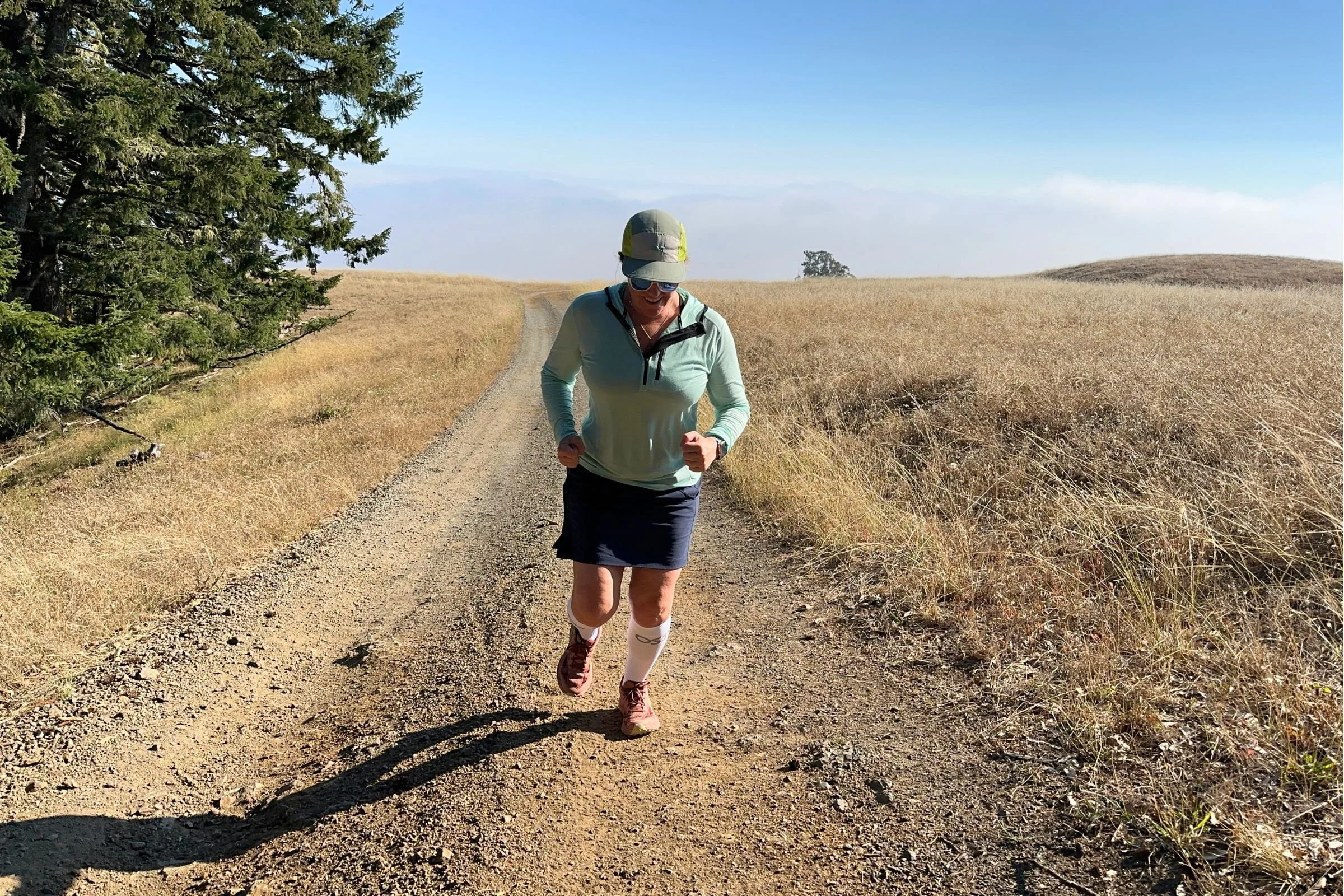   A runner tests the white OS1st Compression Bracing Socks on an exposed trail, where their moisture-wicking fabric and medium underfoot cushioning offer comfort despite the socks' notably tight compression.  