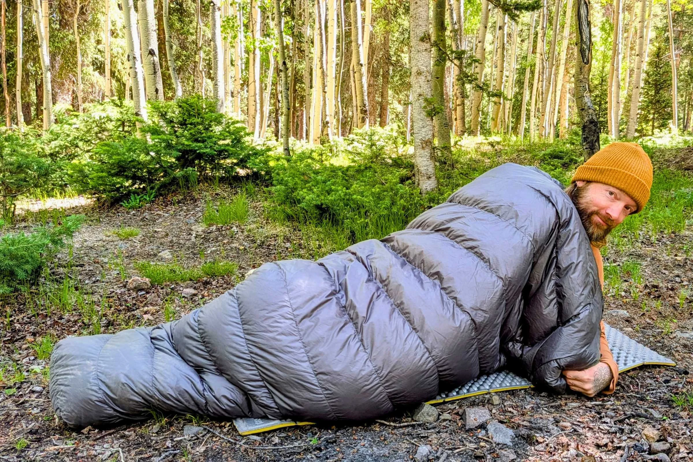 Outdoor Vitals StormLoft 15 Down TopQuilt — man lying in the woods