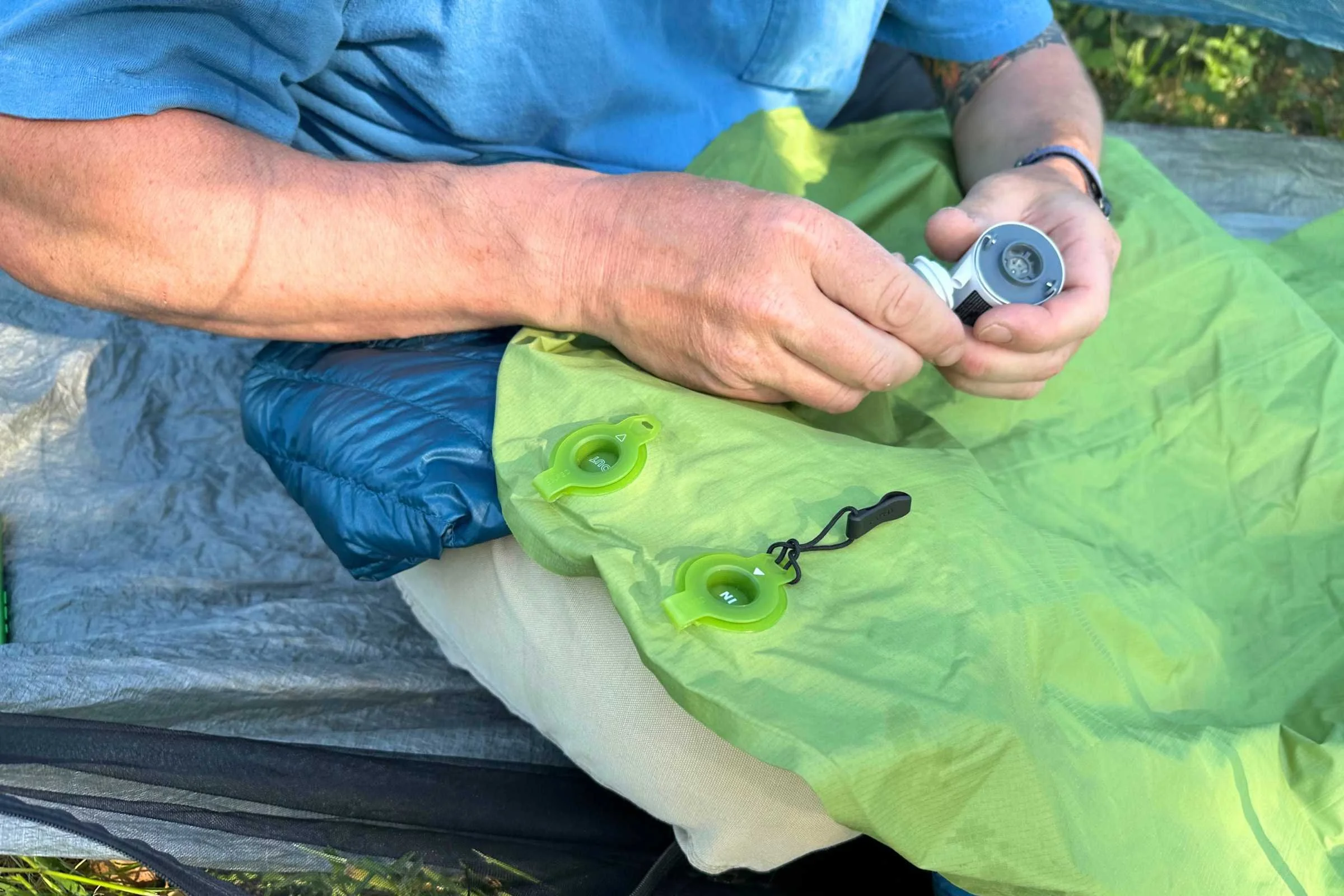 Showing the in and out valves on the EXPED Ultra 6.5R mummy sleeping pad. Tester is about to use a small electric pump to air it up.