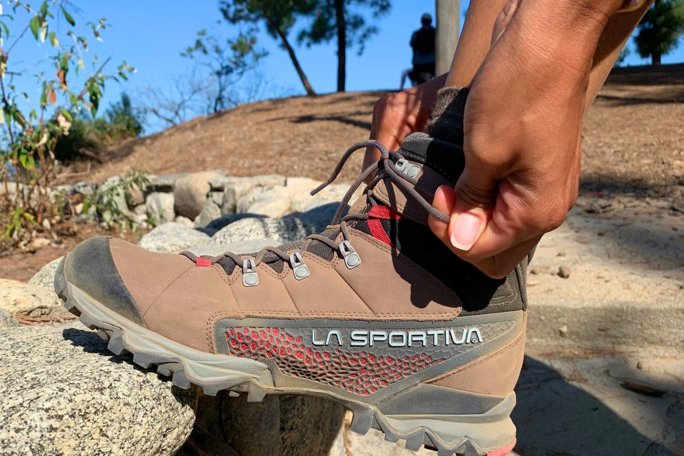 Hiker testing ultralight boots on challenging rocky terrain showing improved agility and performance