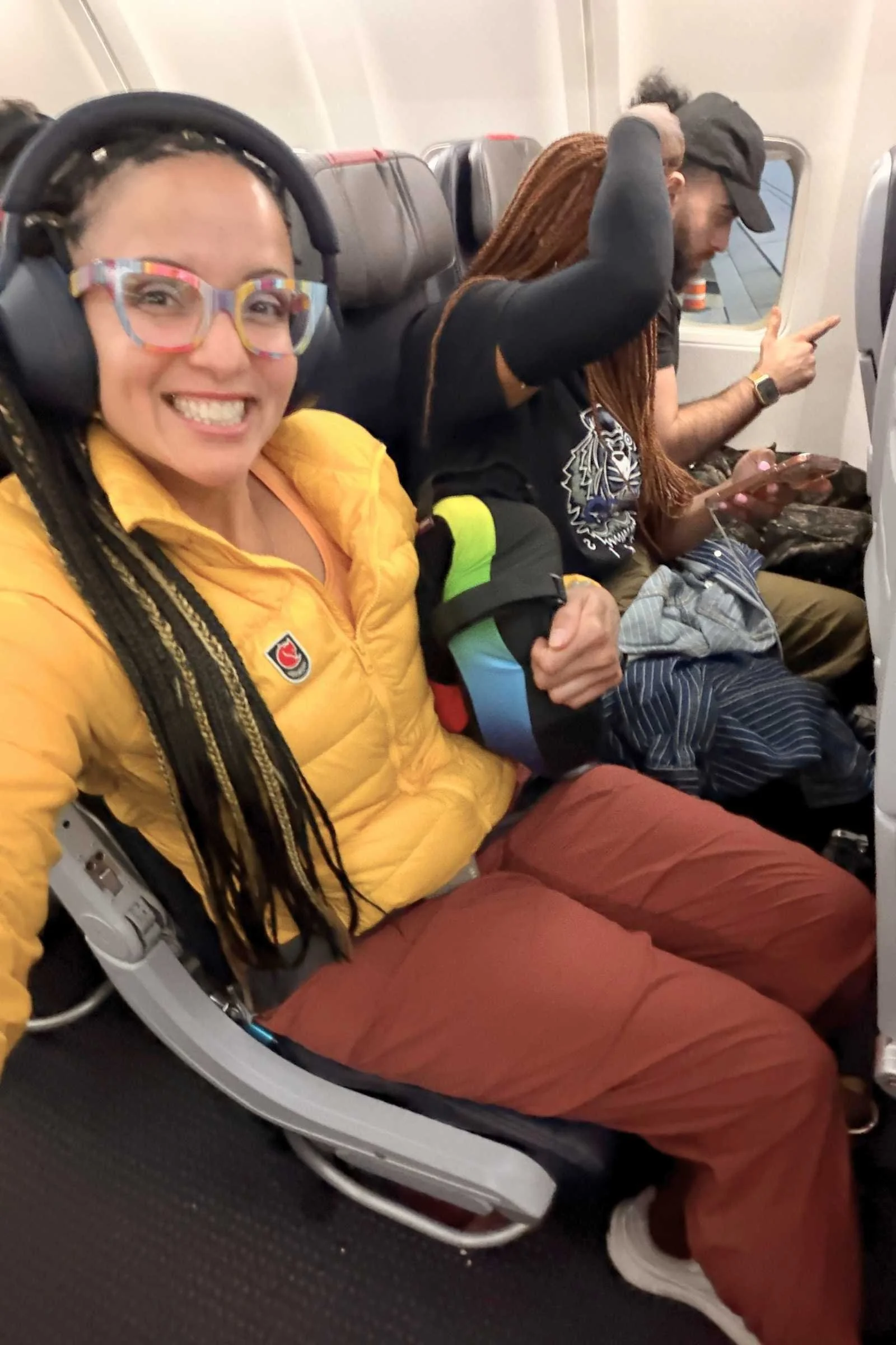 Woman wearing REI Co-op Trailmade Relaxed travel pants in brick red on an airplane