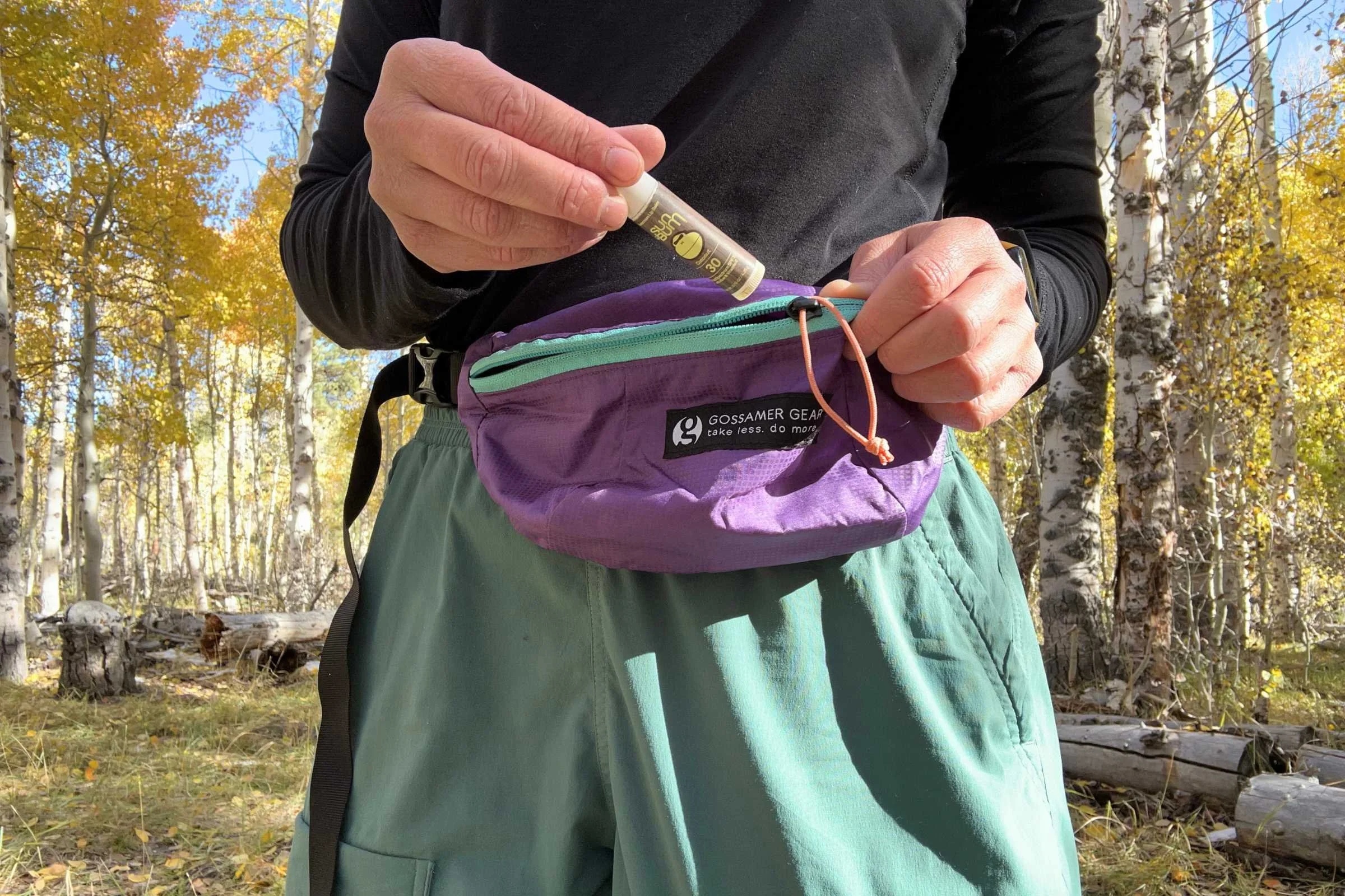 Pulling Sun Bum SPF 30 lip balm out of a fanny pack