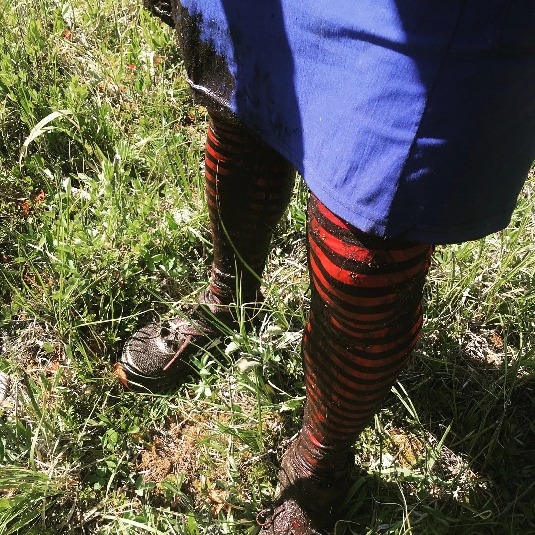 Muddy, wet legs of a hiker who is thankfully wearing a pair of Darn Tough Hiker Micro Crew Midweight hiking socks