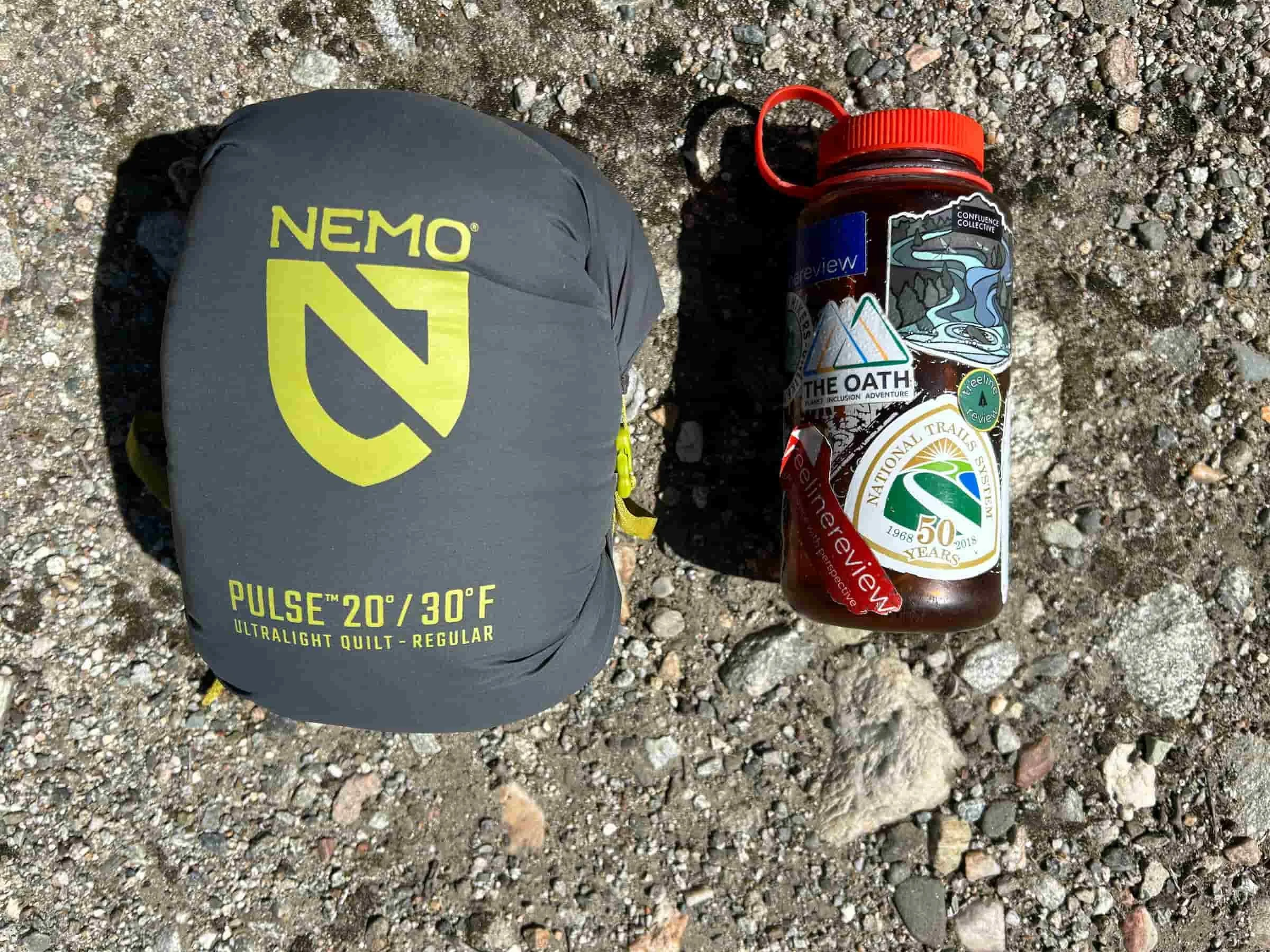 Comparing the compressed NEMO Pulse quilt to the size of a Nalgene.