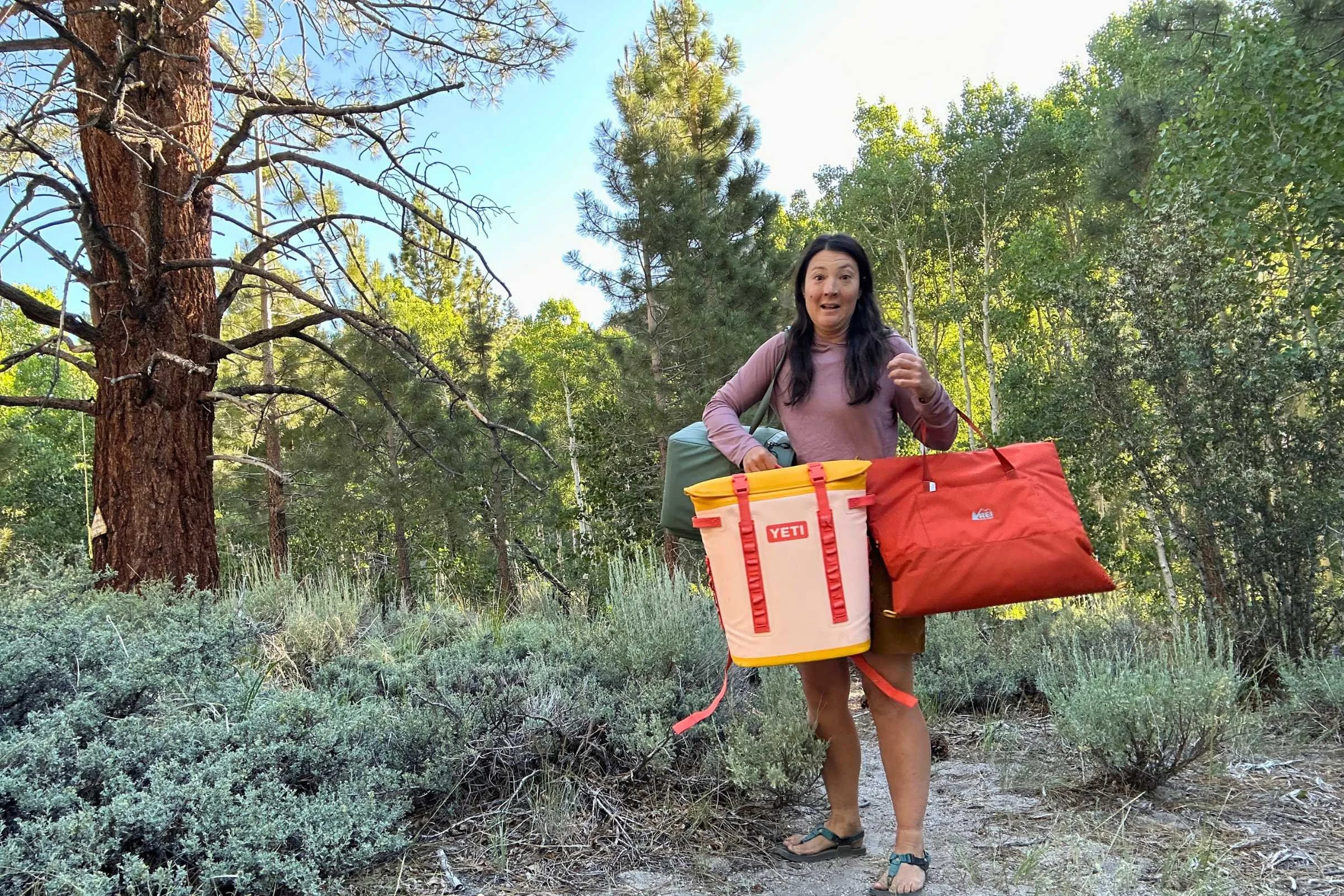 The author testing the YETI Hopper M20 2.0 backpack soft cooler on a camping trip side-by-side with other coolers.