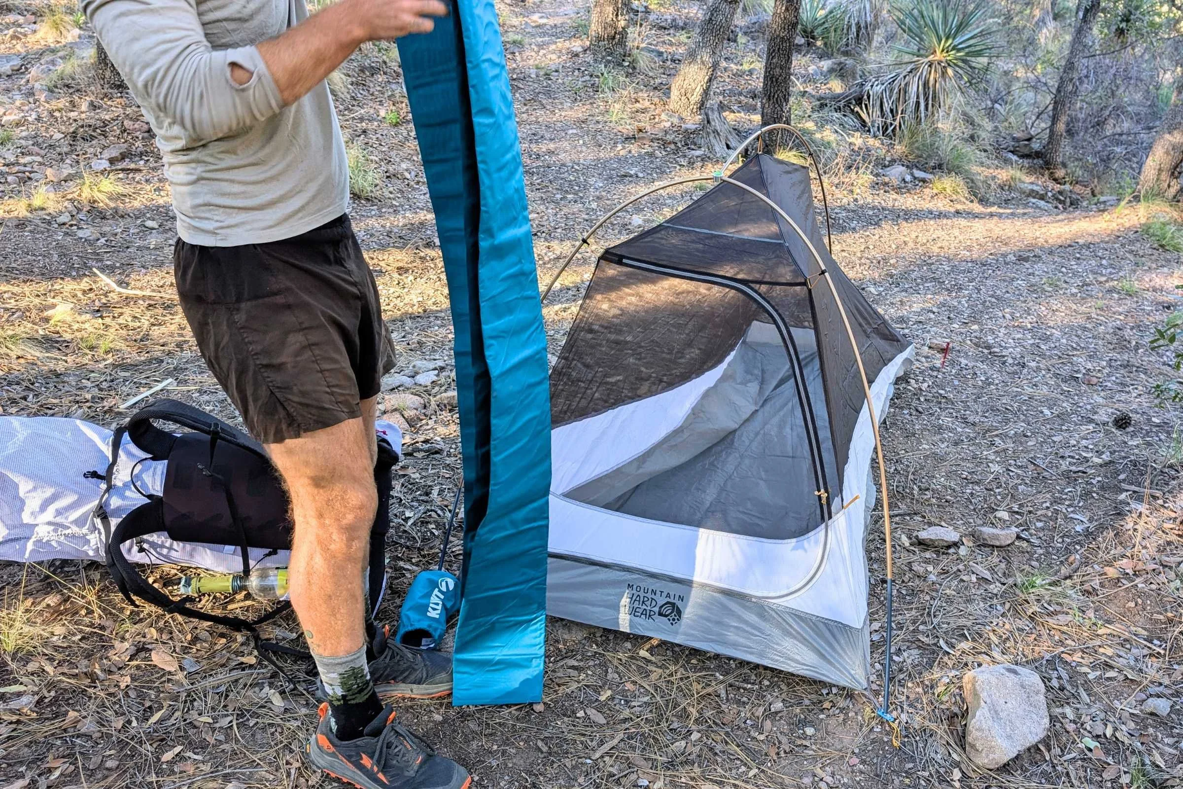 Backpacker unfolding a sleeping pad on the Mountain Hardwear Nimbus UL tent
