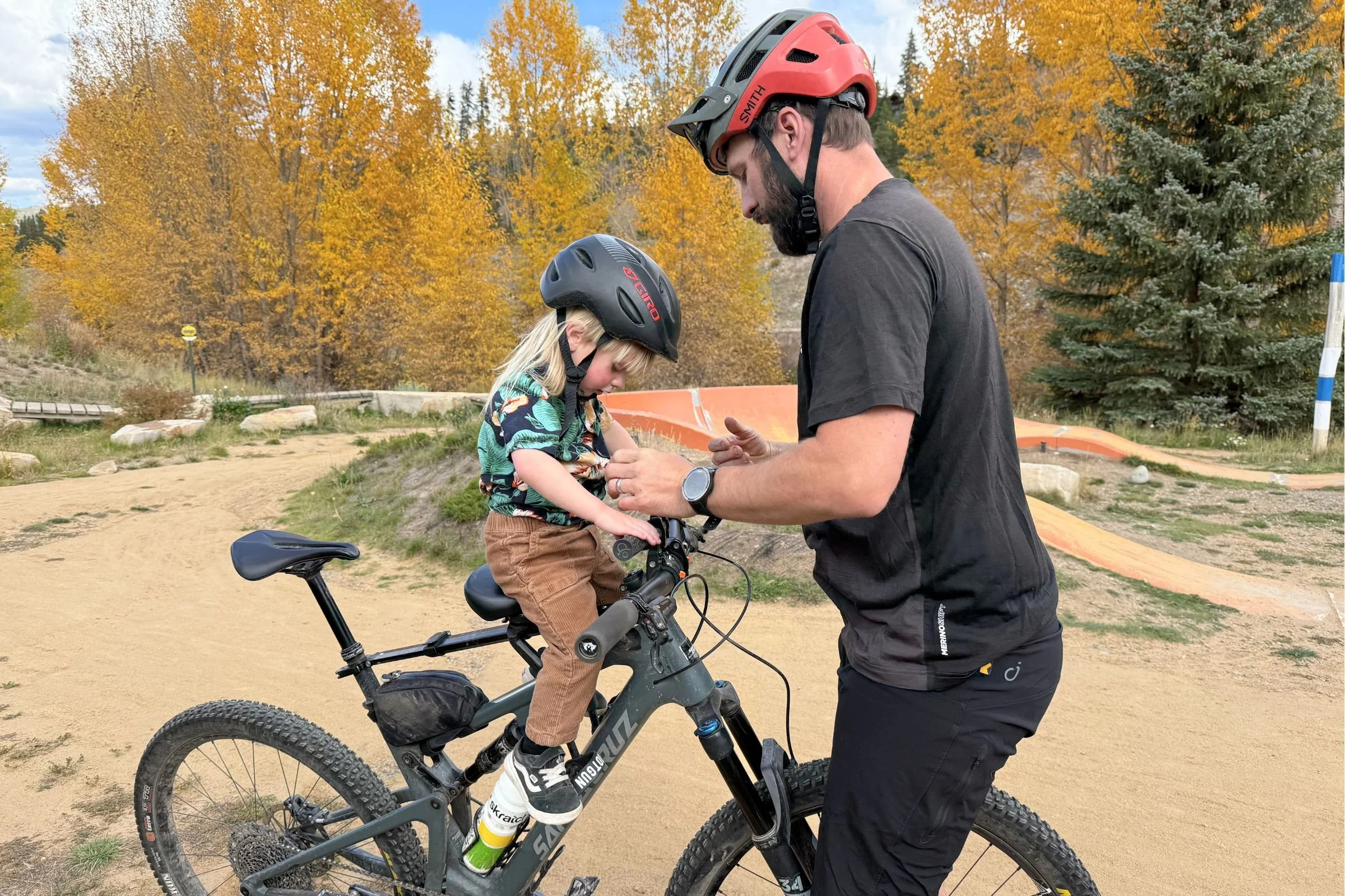 Adult and child riding a bicycle in a dirt setting with the Kids Ride Shotgun Shotgun Pro Evo.