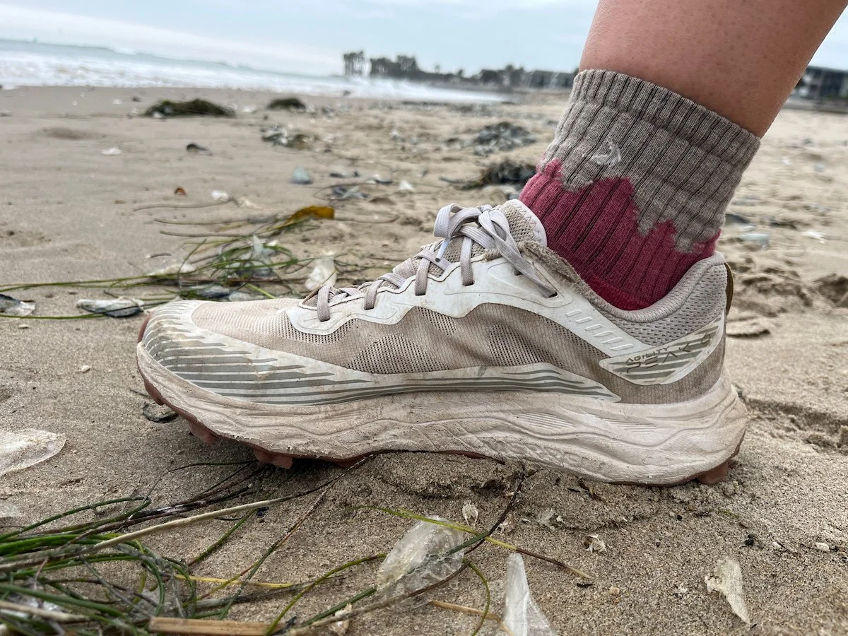 Closeup of a person wearing the Darn Tough Hiker Midweight quarter crew socks on a sandy beach