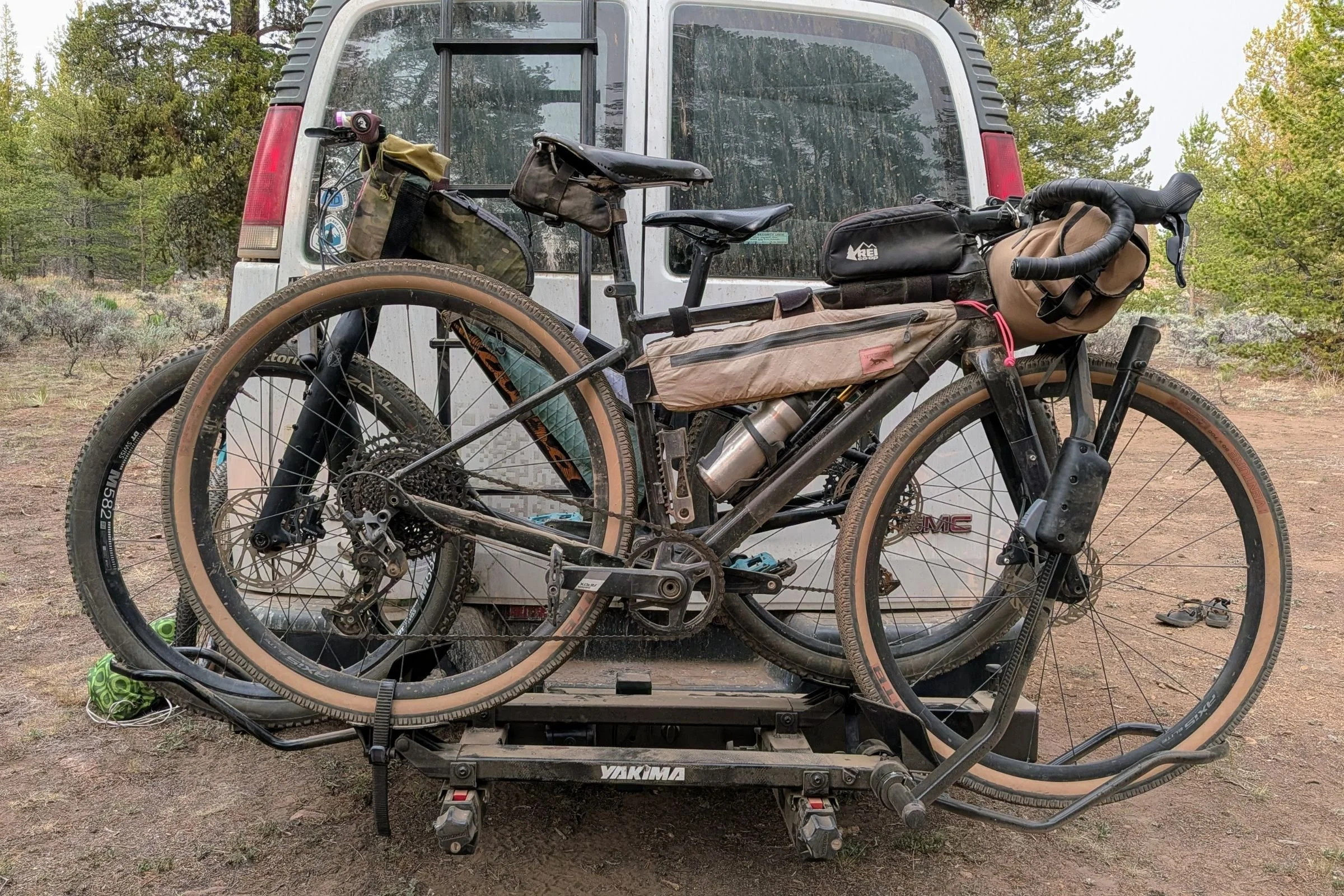 A van equipped with a Yakima EXO Swing on the back carrying two loaded bicycles.