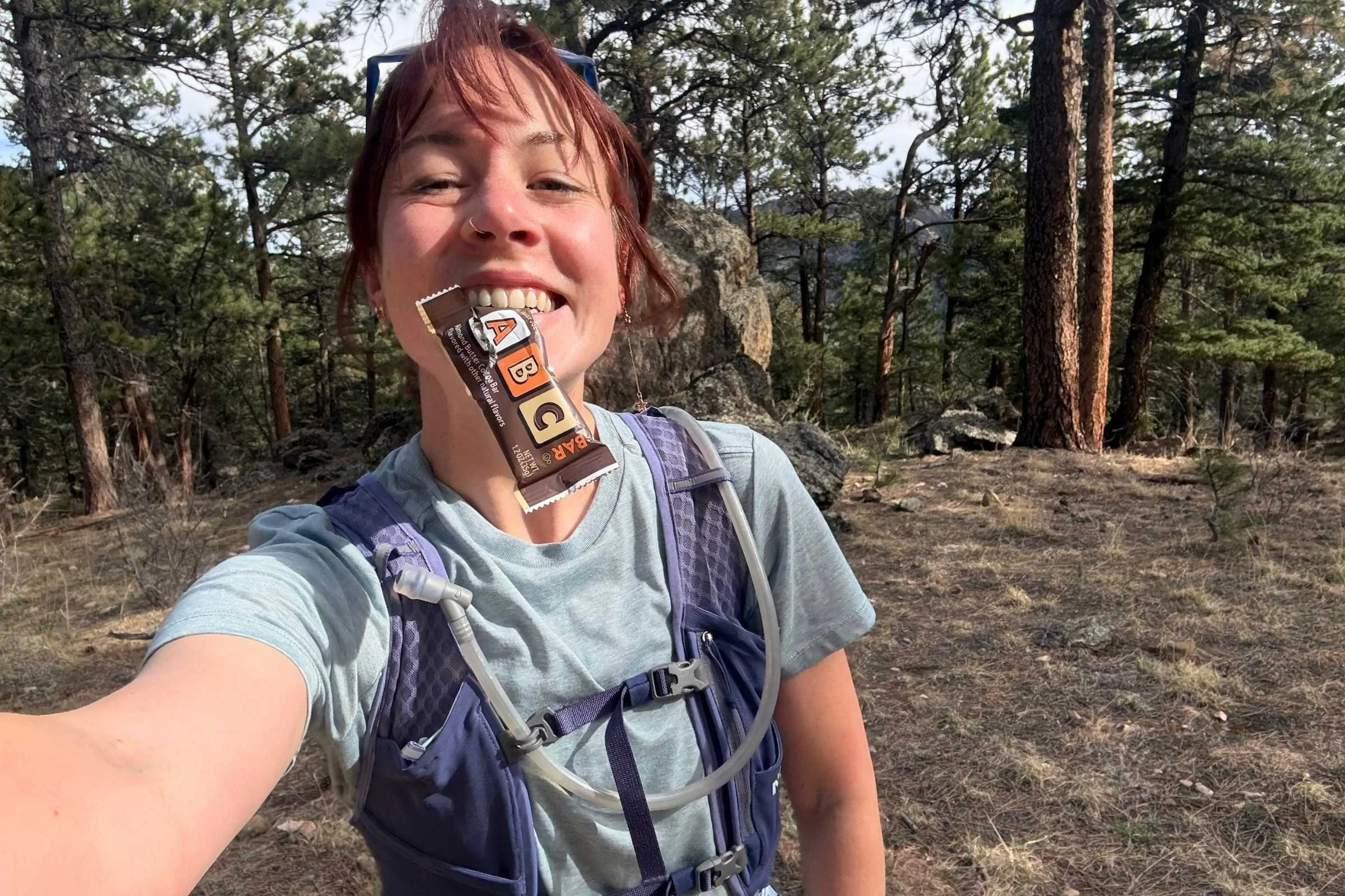 treeline writer becca downs eating a trader joe’s abc bar mid trail run