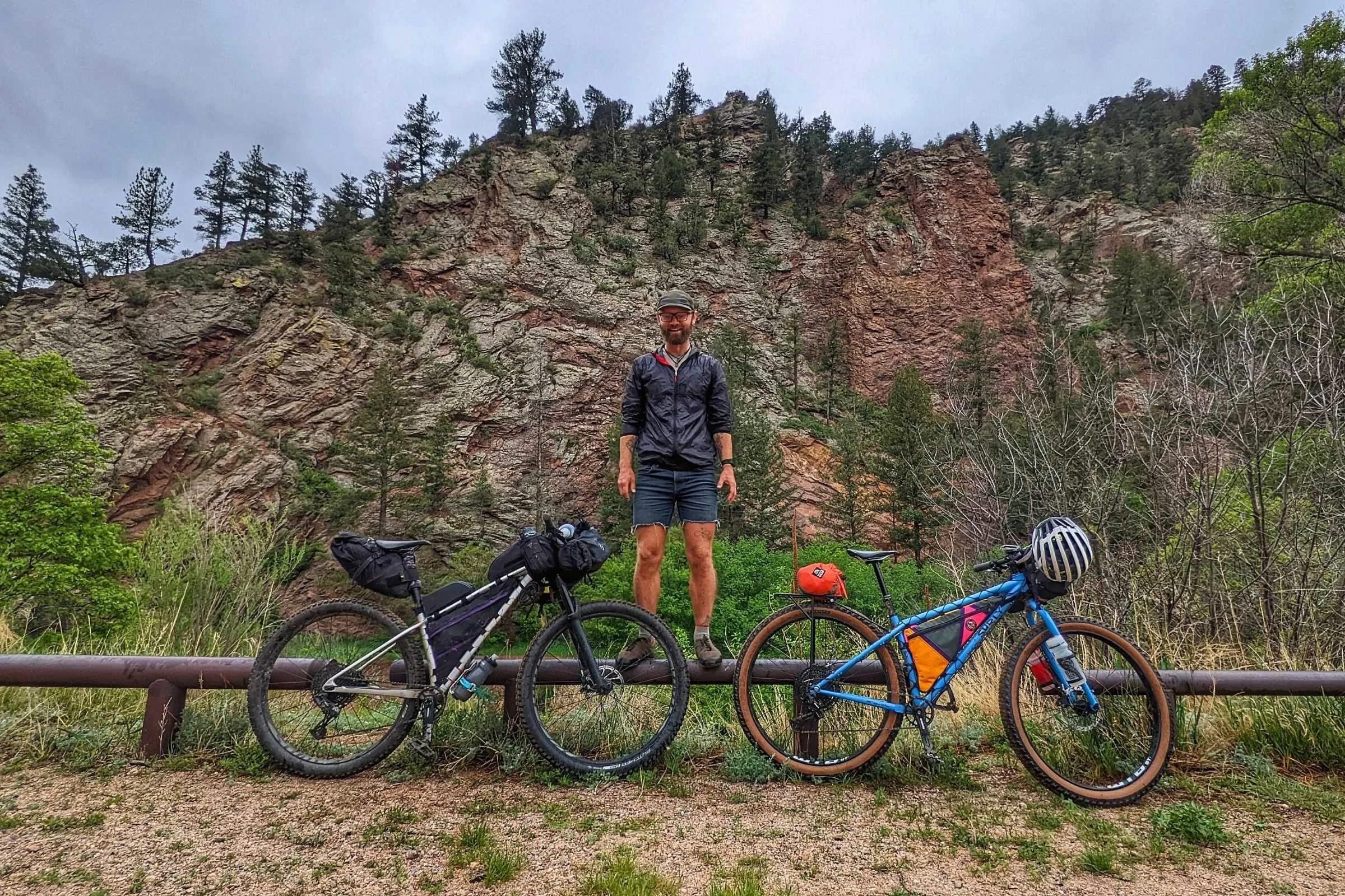 Person standing behind two bikes with bike bags on them