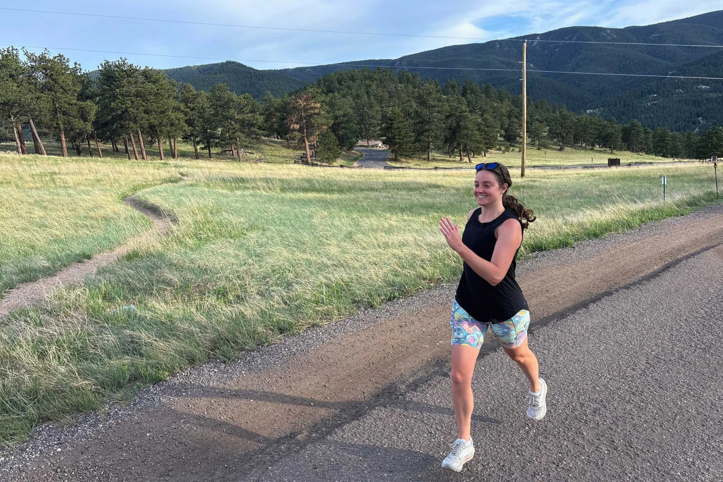 Best Road Running Shorts for Women on a paved path with a grassy field and trees in the background.