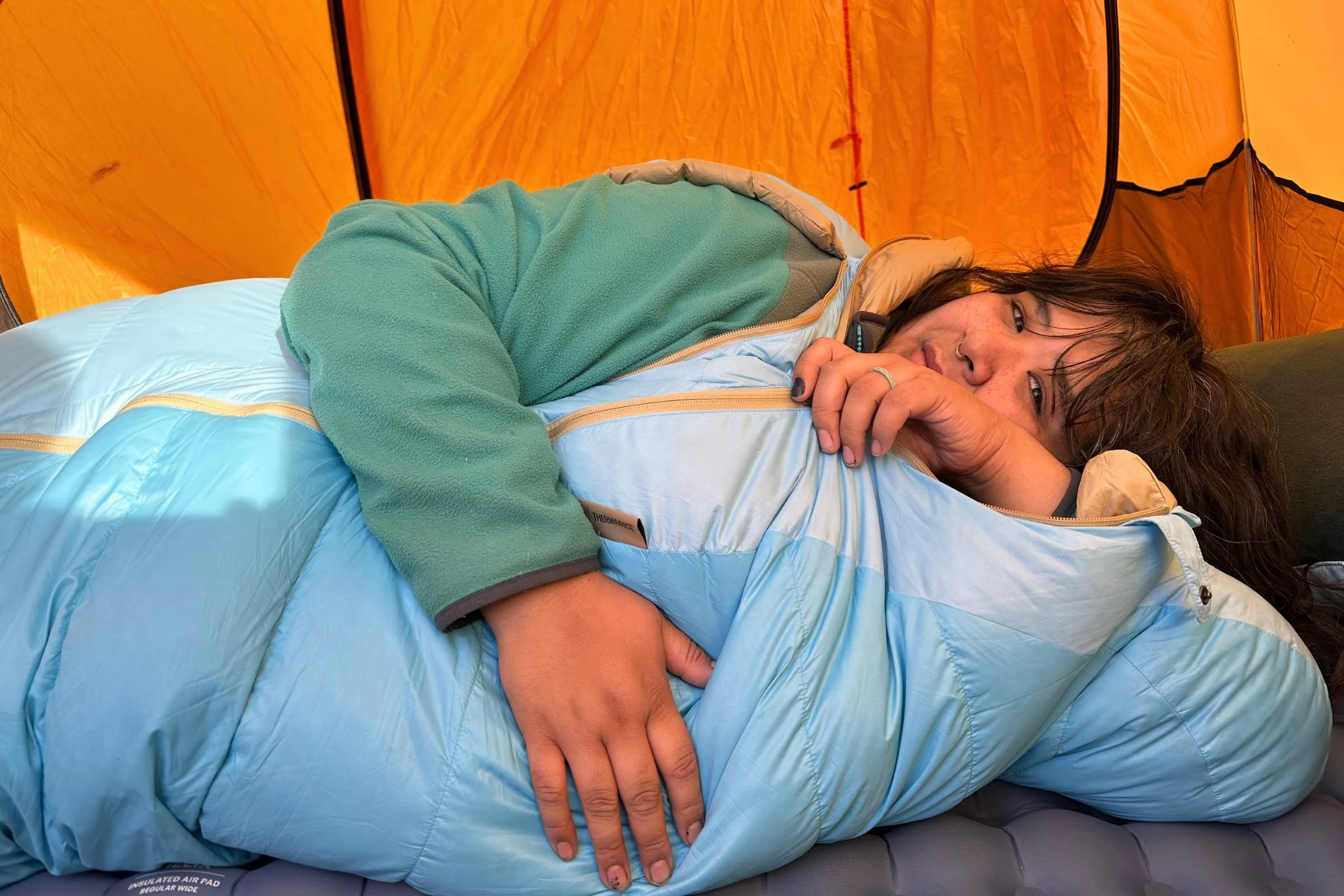 Lying on the side in the Therm-a-Rest Boost 650 with one arm out of the unzipped arm hole.