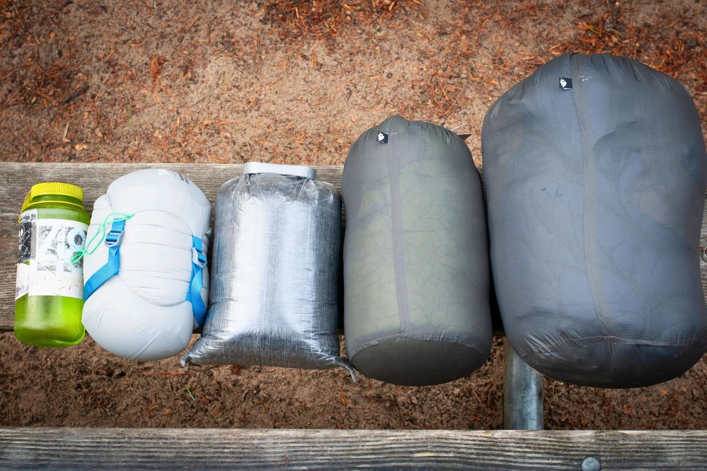 From left to right: a Nalgene bottle, the Therm-a-Rest Vesper 30, the Zpacks Solo Quilt 20, Enlightened Equipment Enigma 20, and Enlightened Equipment Apex Revelation 20