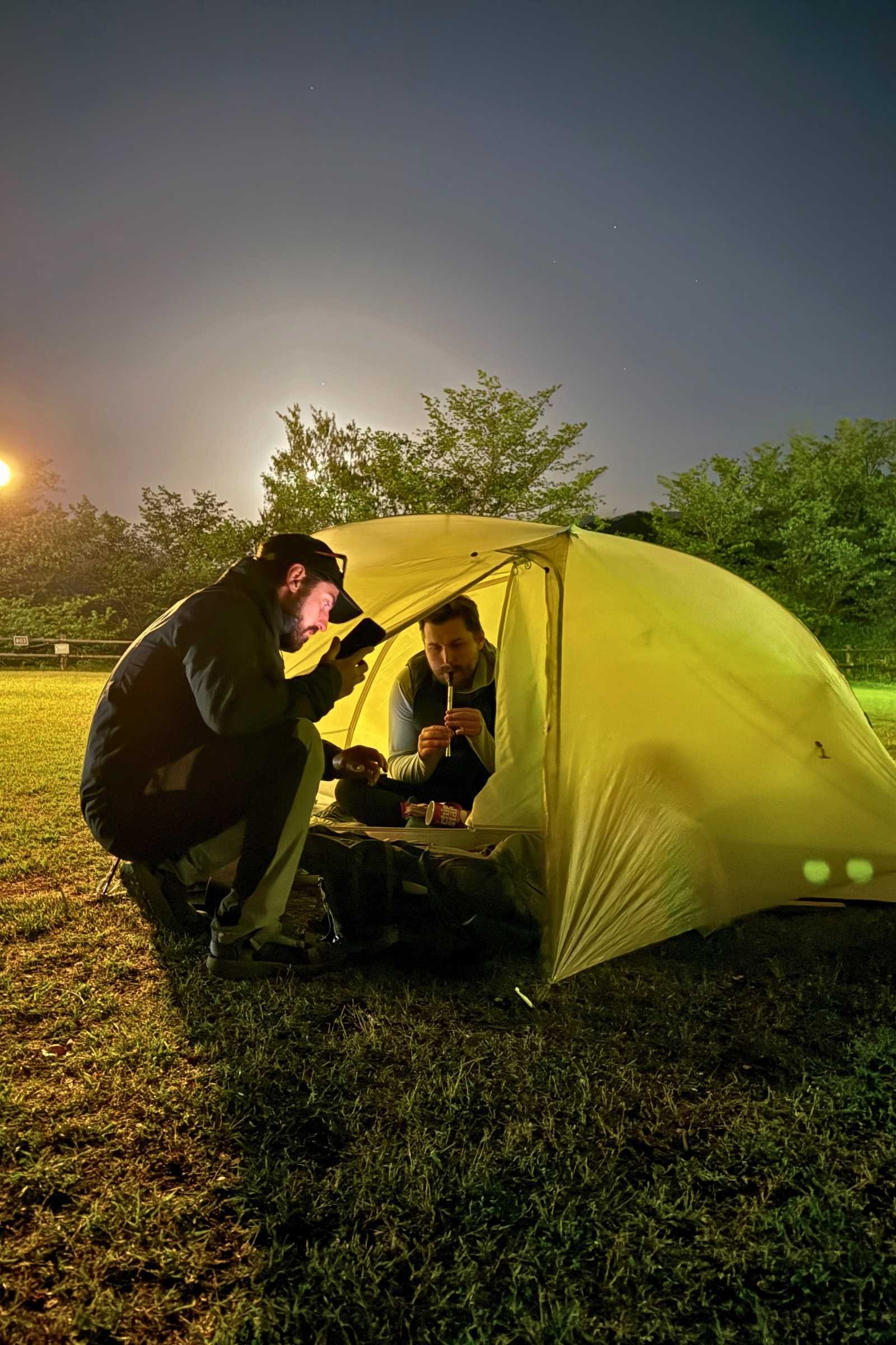 Man plays tin whistle in a tent