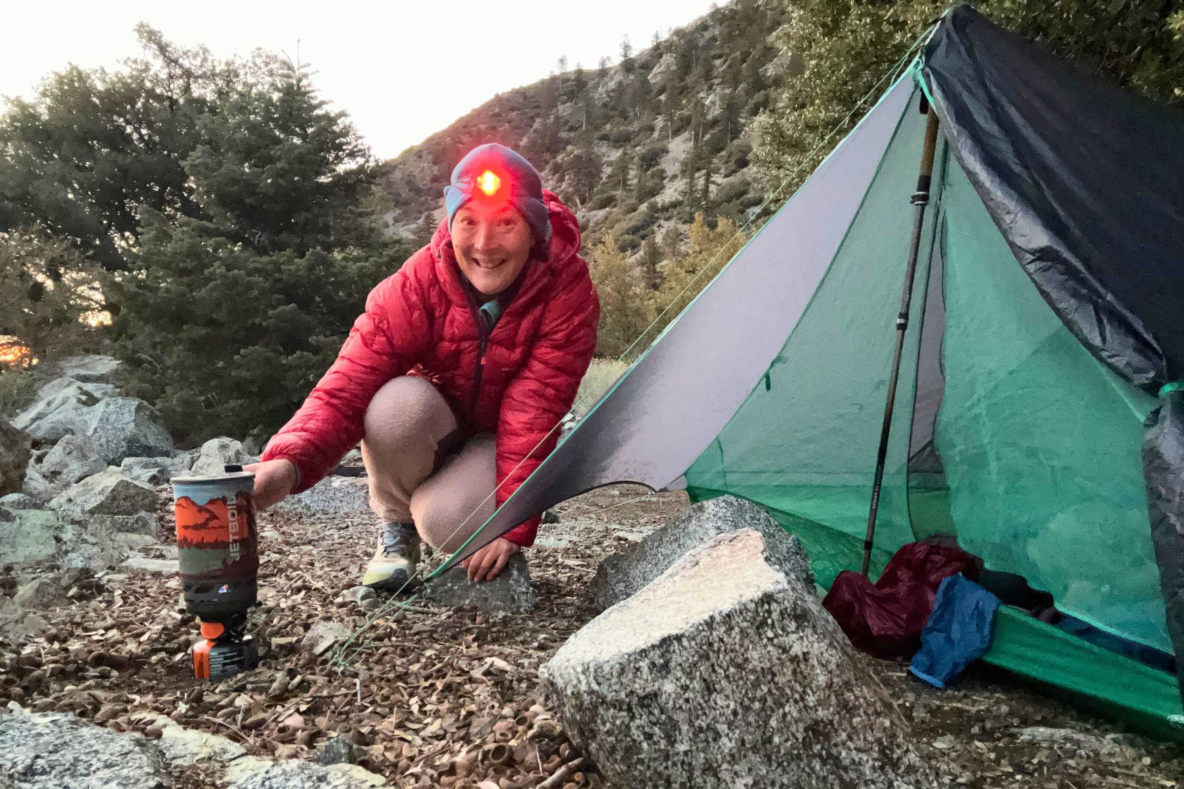 Backpacker cooking beside Big Agnes String Ridge VST ultralight tent at alpine campsite