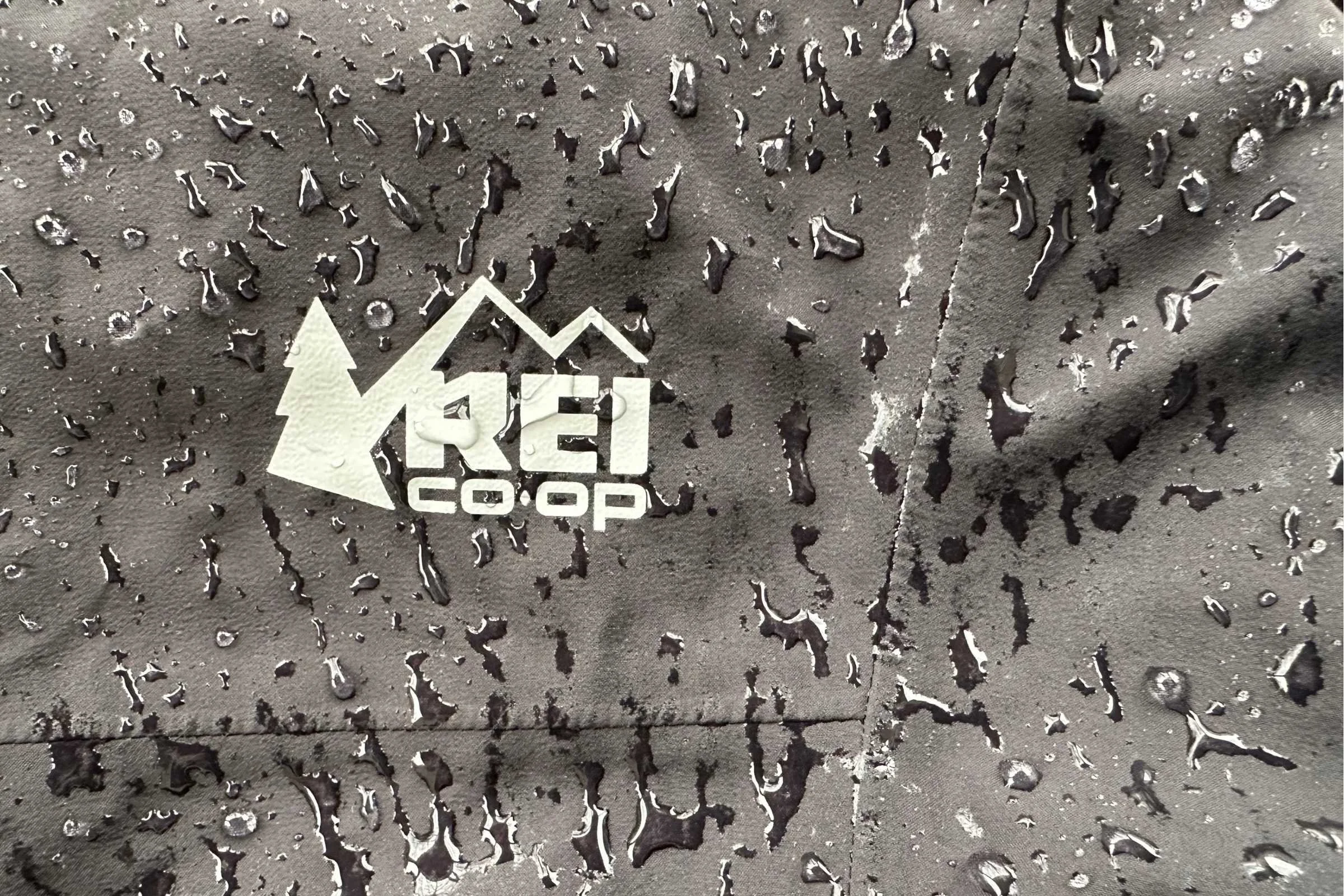 Close-up of water beading and the fabric texture of the REI Co-op XeroCloud rain pants.