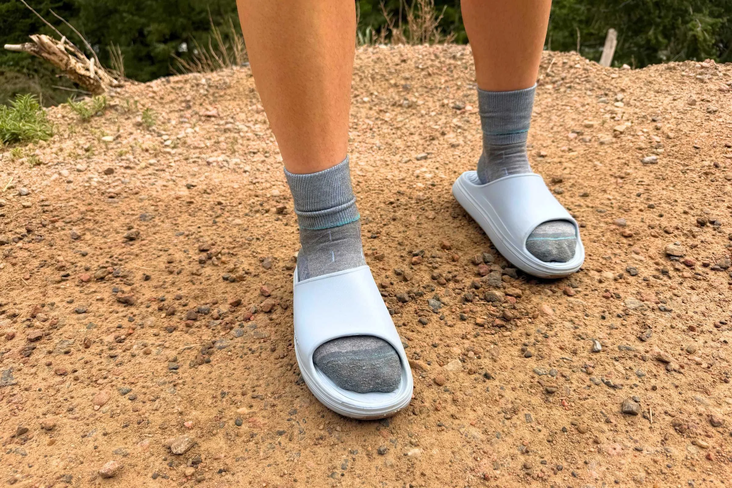Norda 008 Recovery Slides: A person wearing grey slippers on a dirt road.