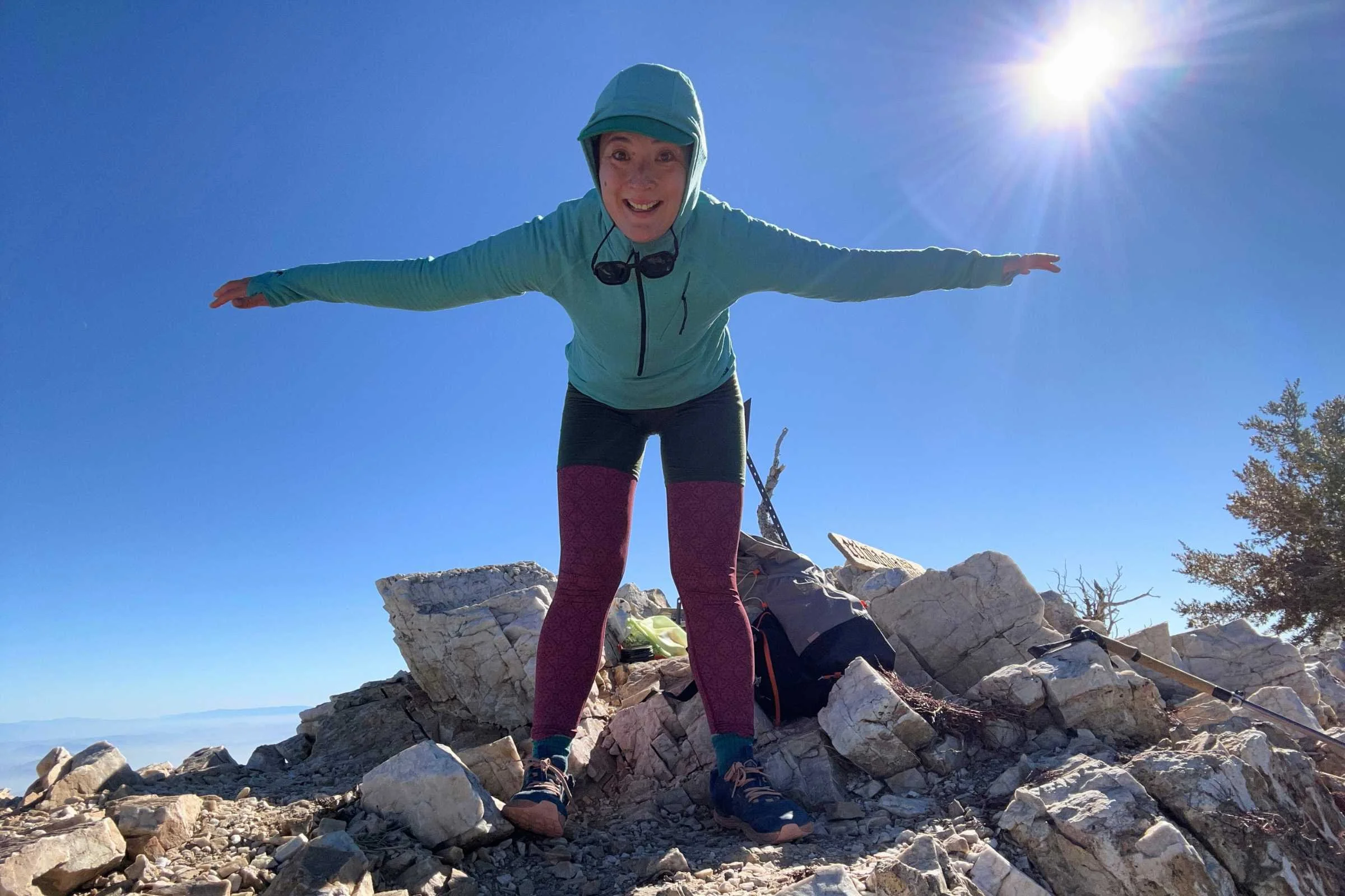 Woman modeling the Minus33 Woolverino Microweight Boxer Briefs (over leggings) while standing on a rocky summit