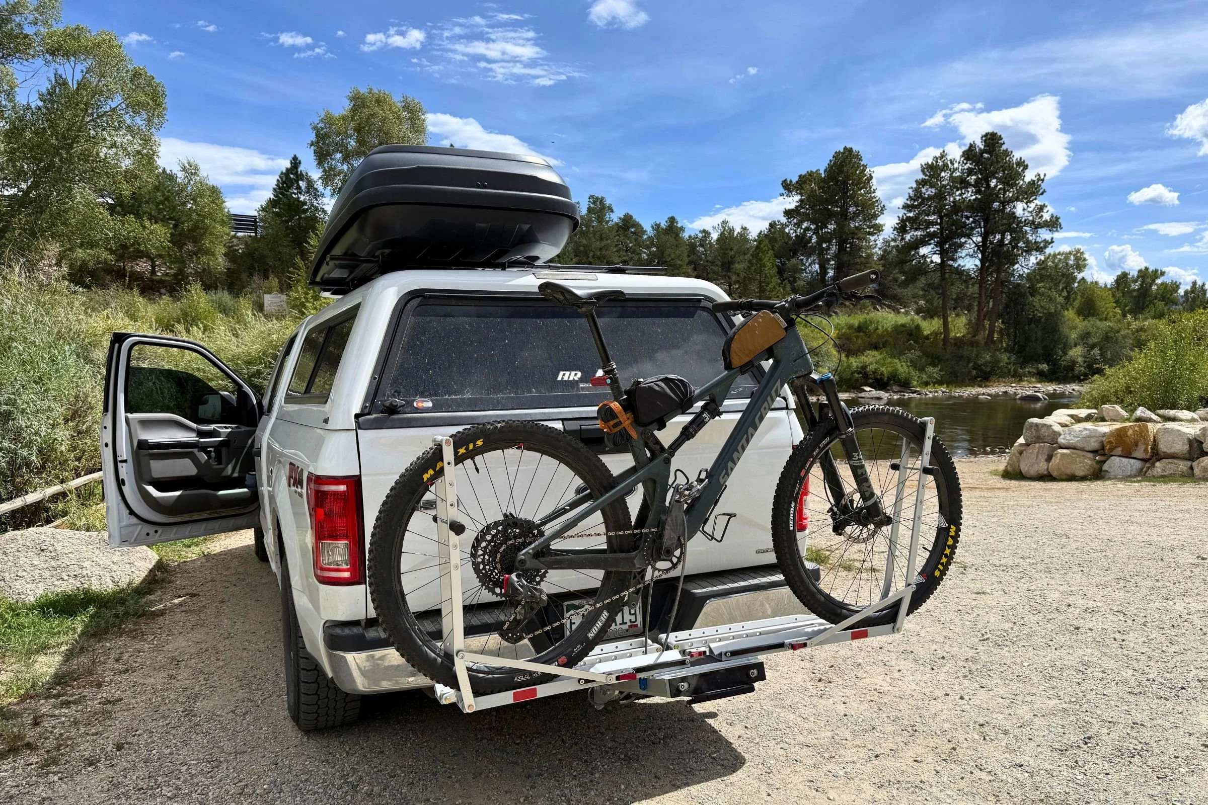 1UP USA Heavy Duty Hitch Bike Rack mounted on a white pickup truck, carrying a bicycle.