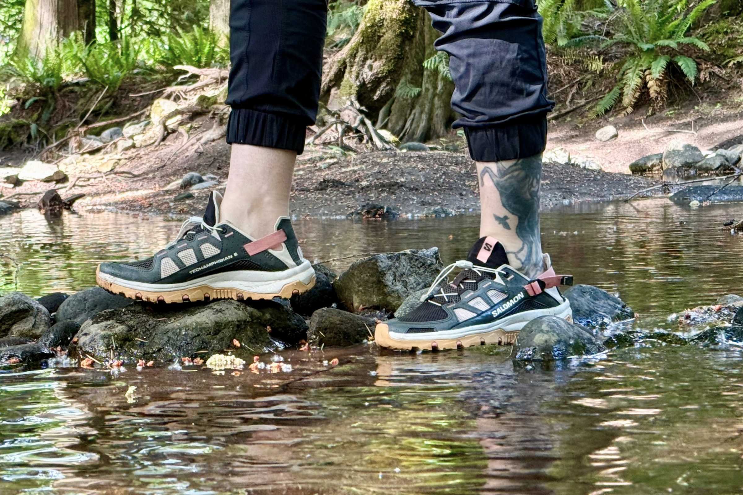 Crossing a stream on rocks wearing the Salomon Techamphibian 5 water shoes