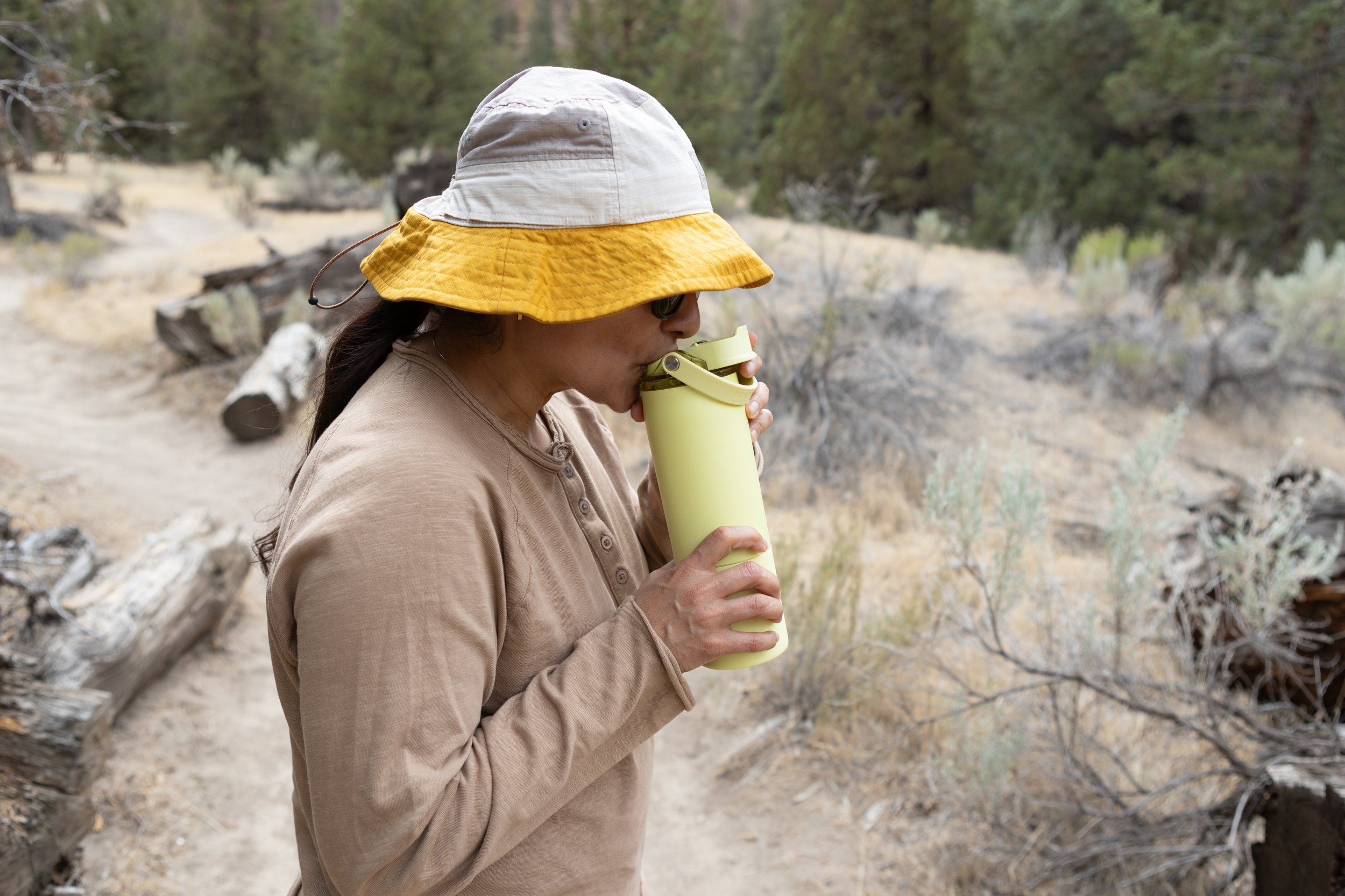 the author drinking from a yellow-green brumate rise insulated water bottle