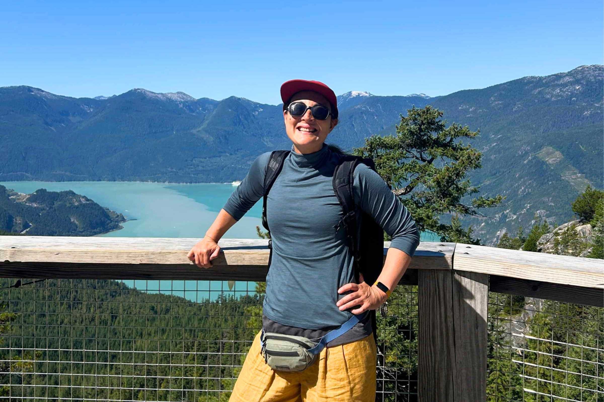 ULA Ultra Dragonfly 30L Adventure Travel Backpack worn by a woman on a wooden platform overlooking a lake.