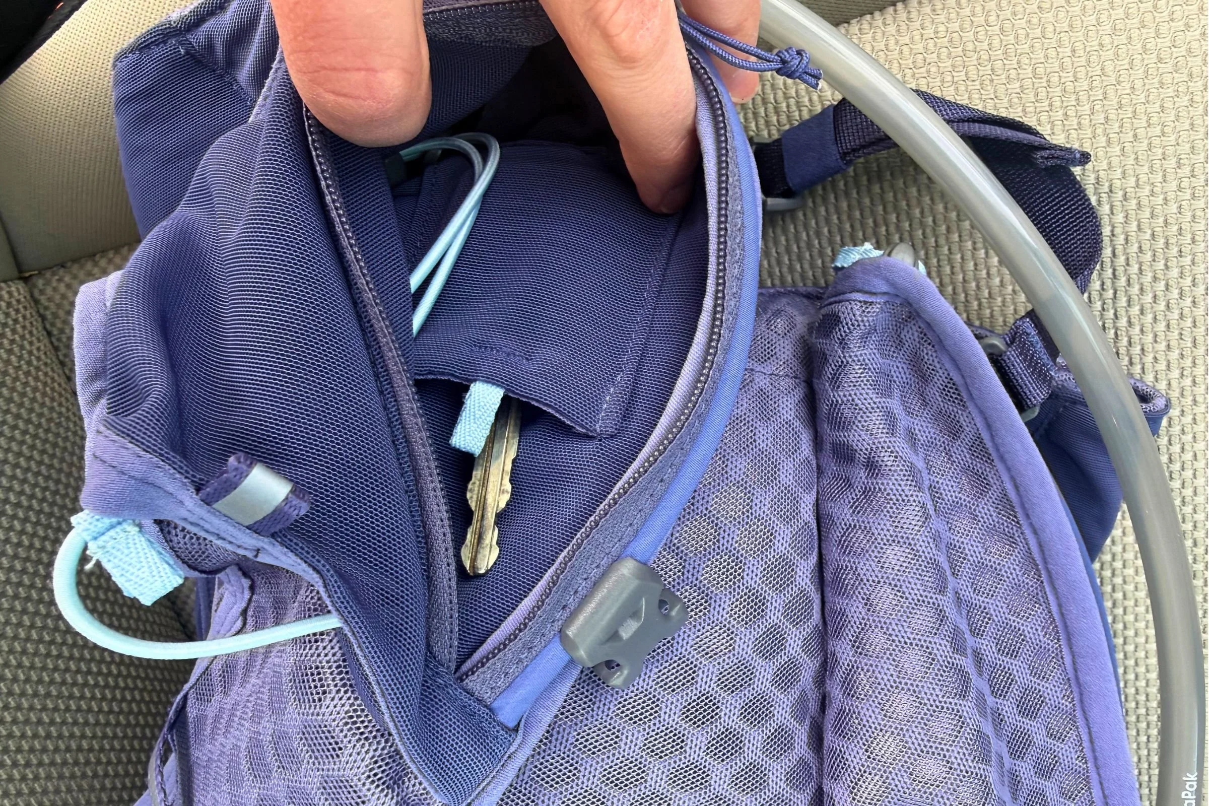 The zippered key pocket has a small carabiner and whistle.