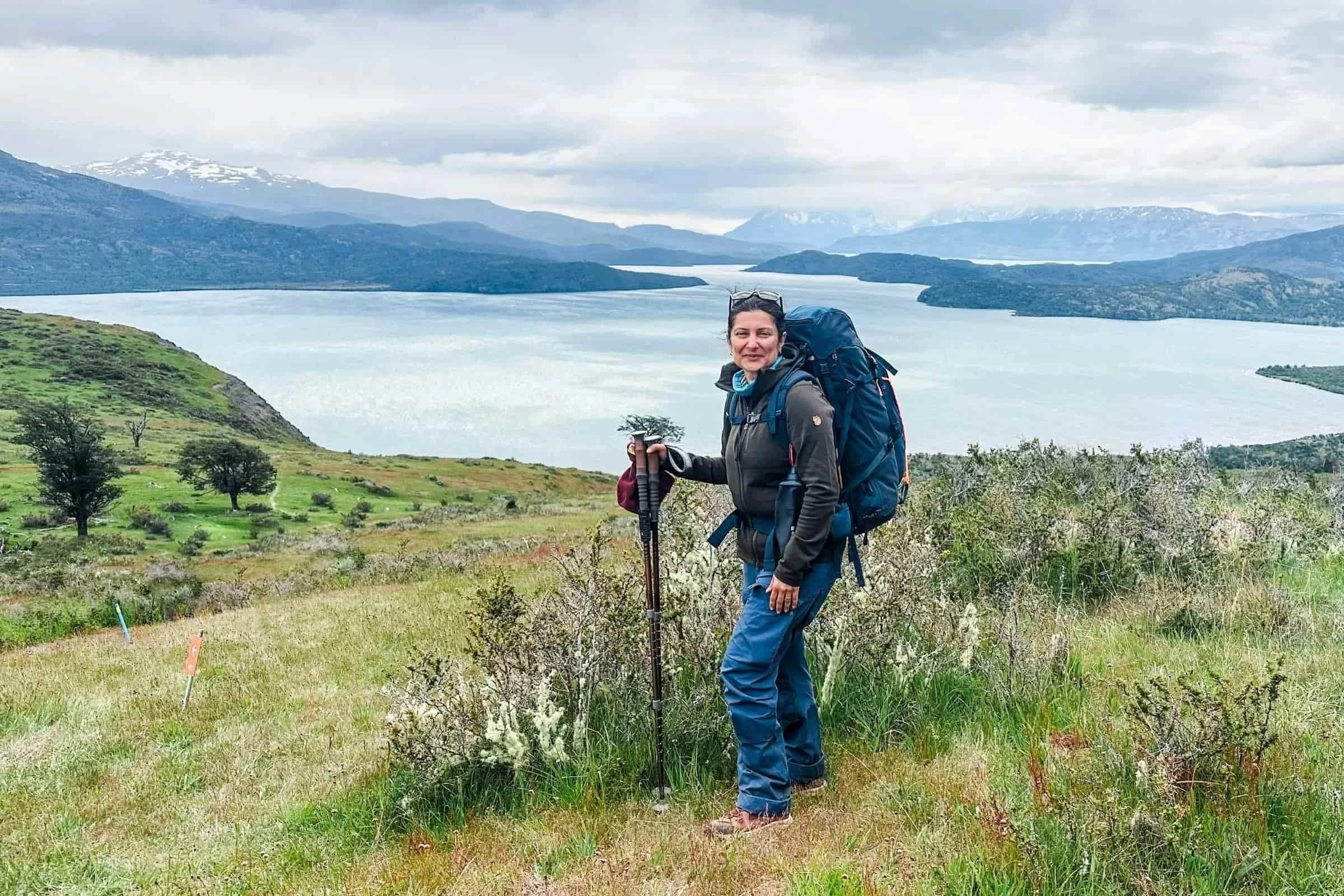karthika gupta backpacking by a lake on a cloudy day